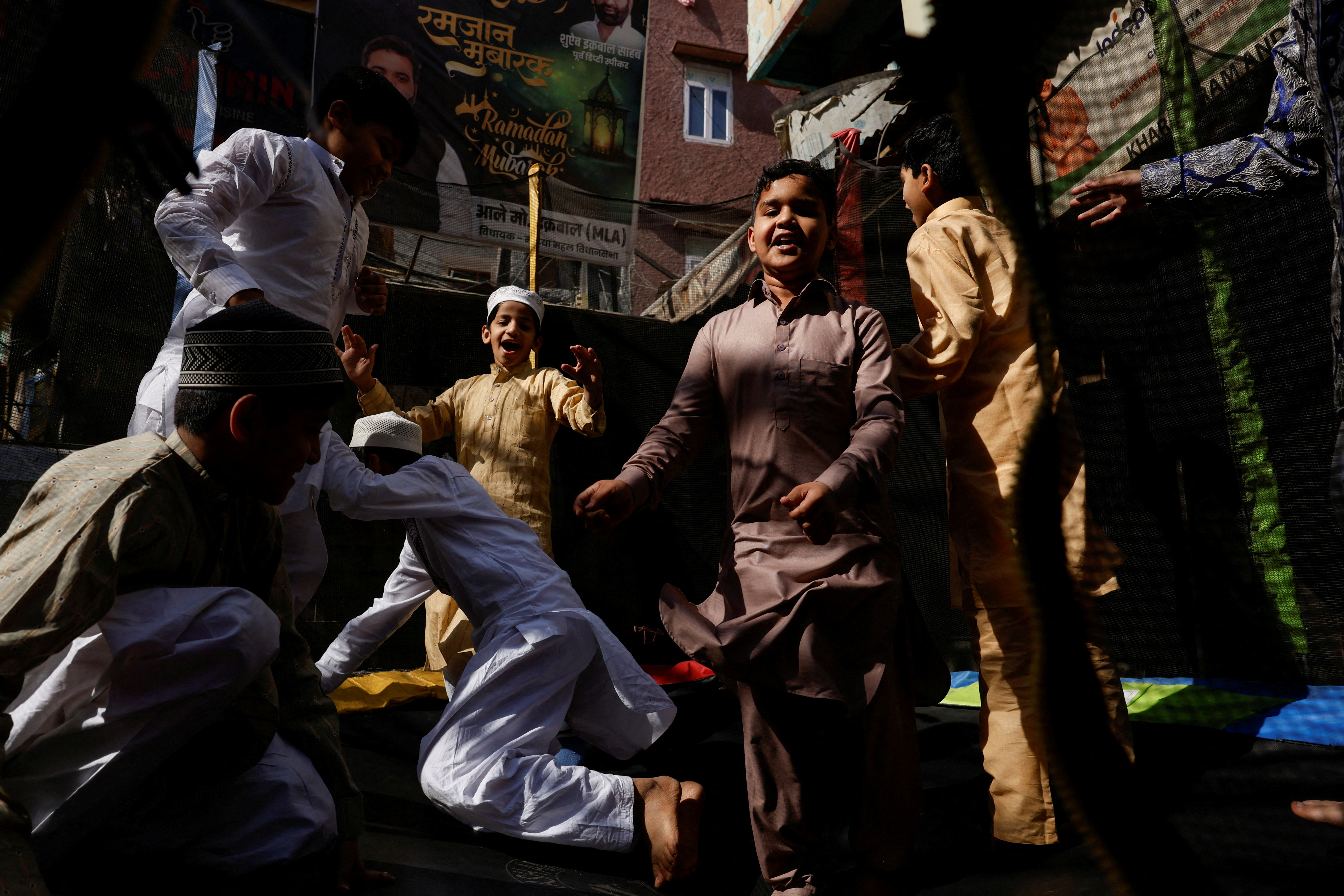 Muslim boys jump on a trampoline on the occasion of Eid al-Fitr, in Delhi