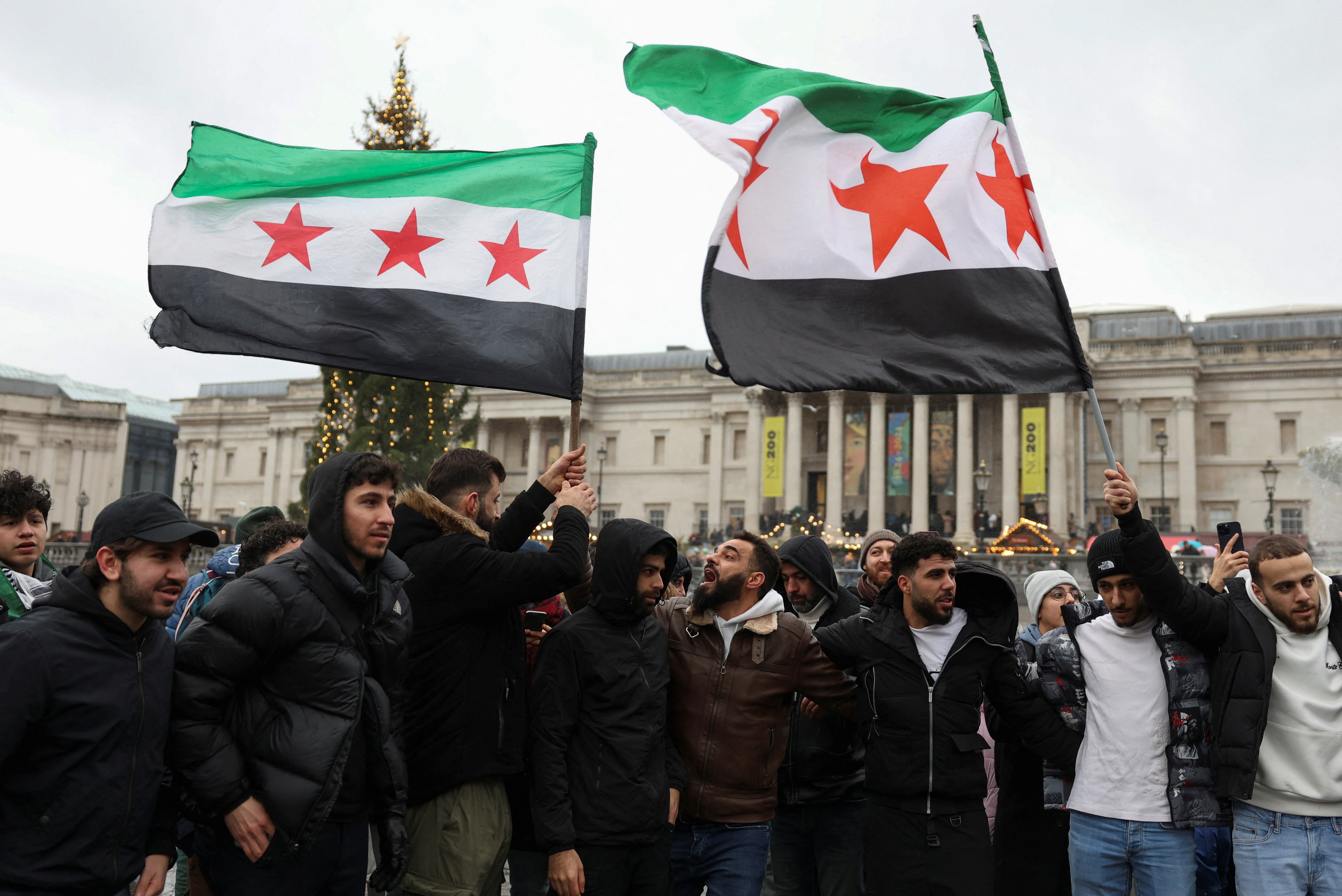 FILE PHOTO: People gather in Trafalgar Square, after Syrian rebels announced that they have ousted Syria's Bashar al-Assad, in London