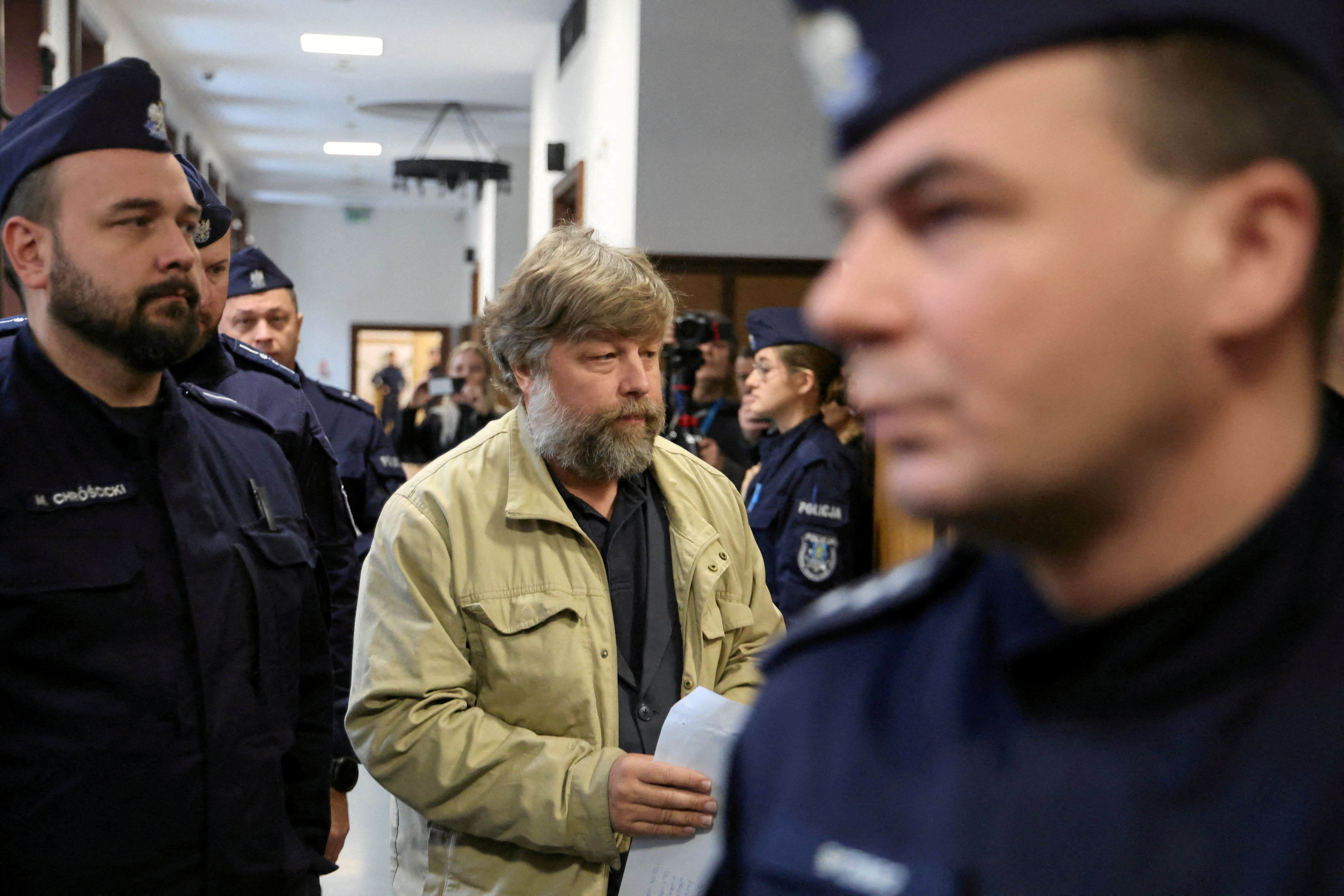 FILE PHOTO: Russian archaeologist Butiagin, who is accused by Ukraine of unauthorised excavation and plundering of historical artefacts in Crimea, is escorted by Polish police as he arrives at a district court in Warsaw
