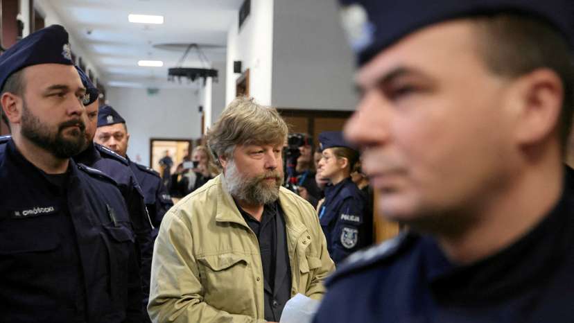 FILE PHOTO: Russian archaeologist Butiagin, who is accused by Ukraine of unauthorised excavation and plundering of historical artefacts in Crimea, is escorted by Polish police as he arrives at a district court in Warsaw