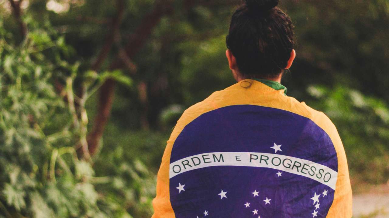 Mulher envolta na bandeira do Brasil