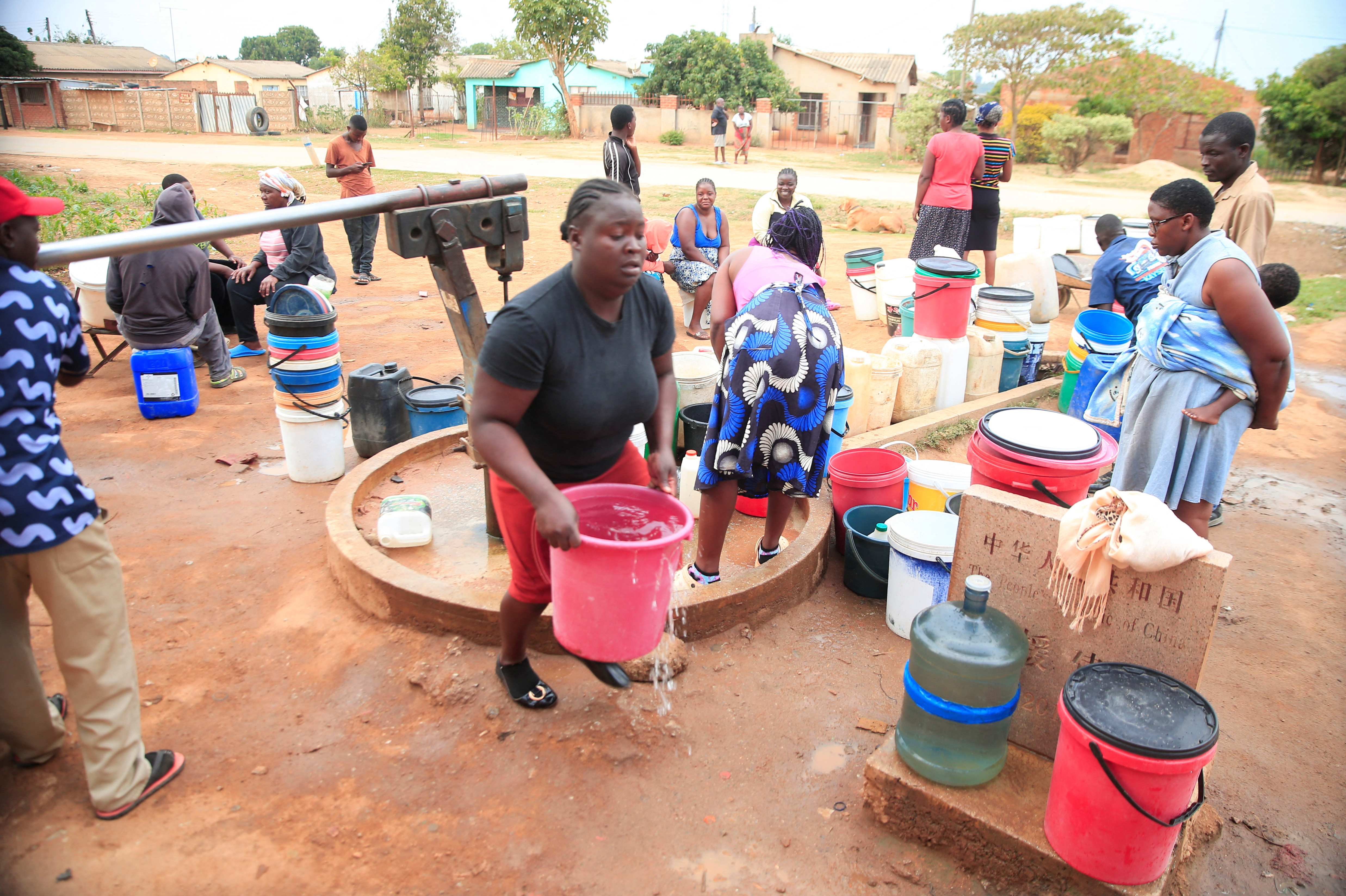 Residents fetch drinking water from a borehole in Marondera