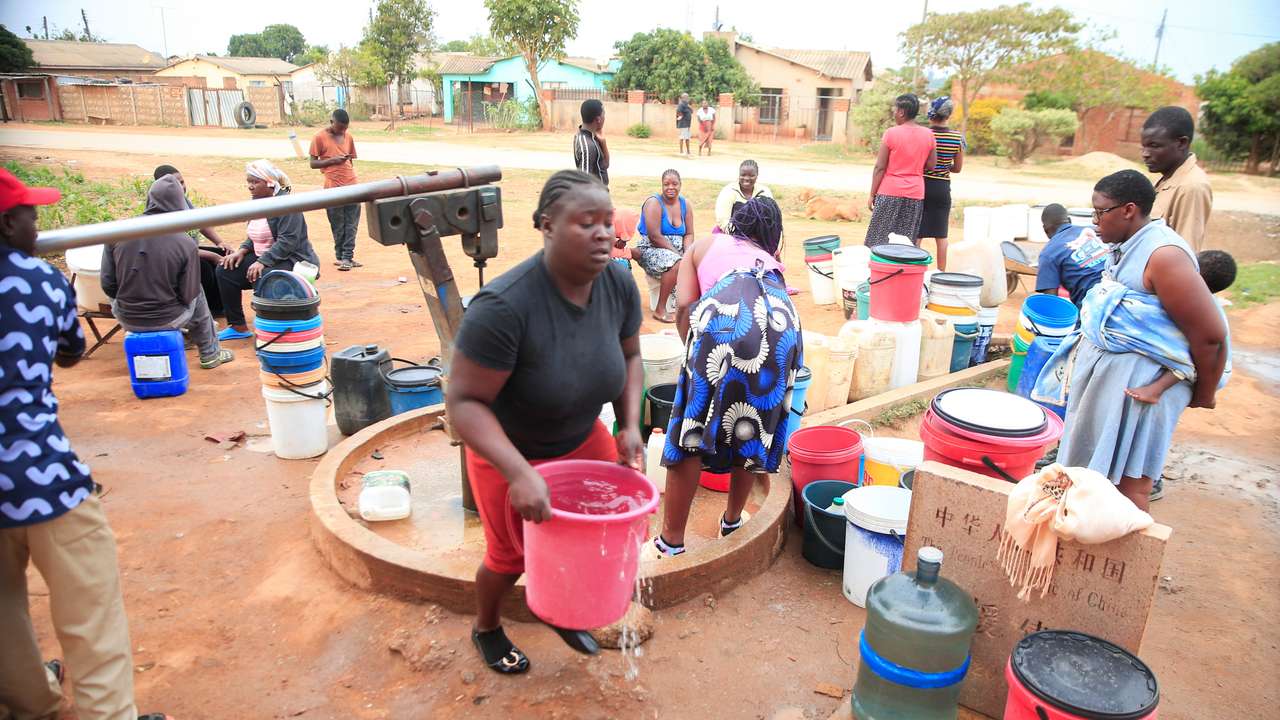 Residents fetch drinking water from a borehole in Marondera