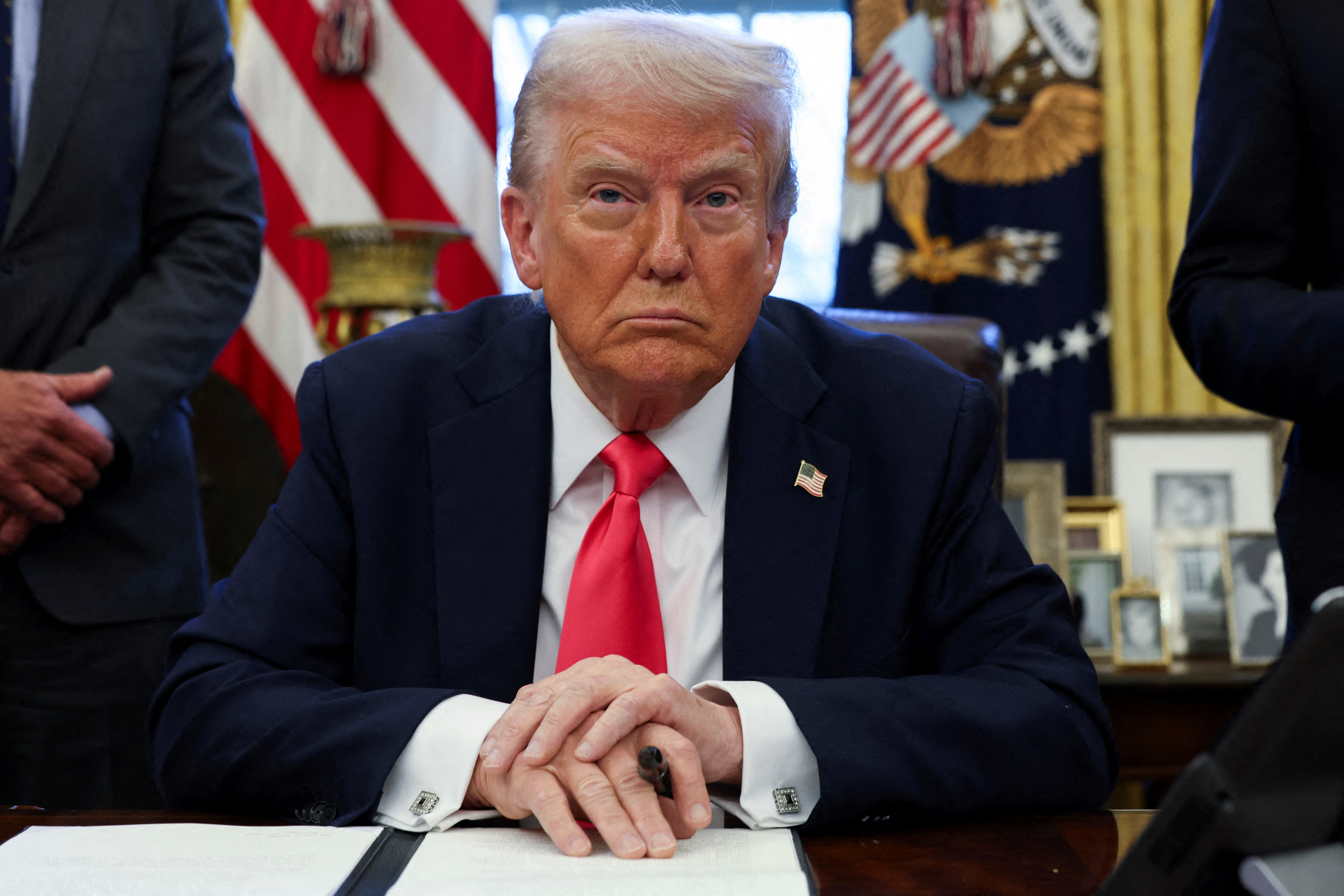 U.S. President Donald Trump signs an executive order in the Oval Office, at the White House in Washington