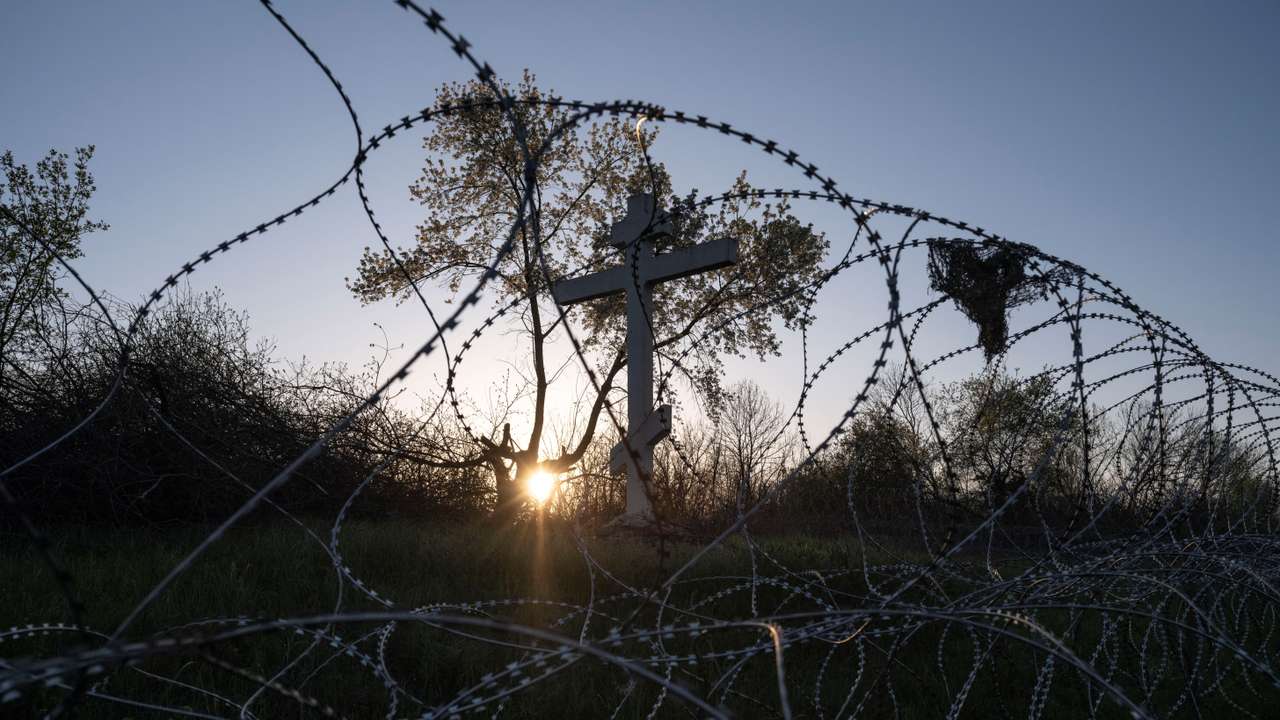 Cross is seen behind razor wire in the frontline town of Kostiantynivka