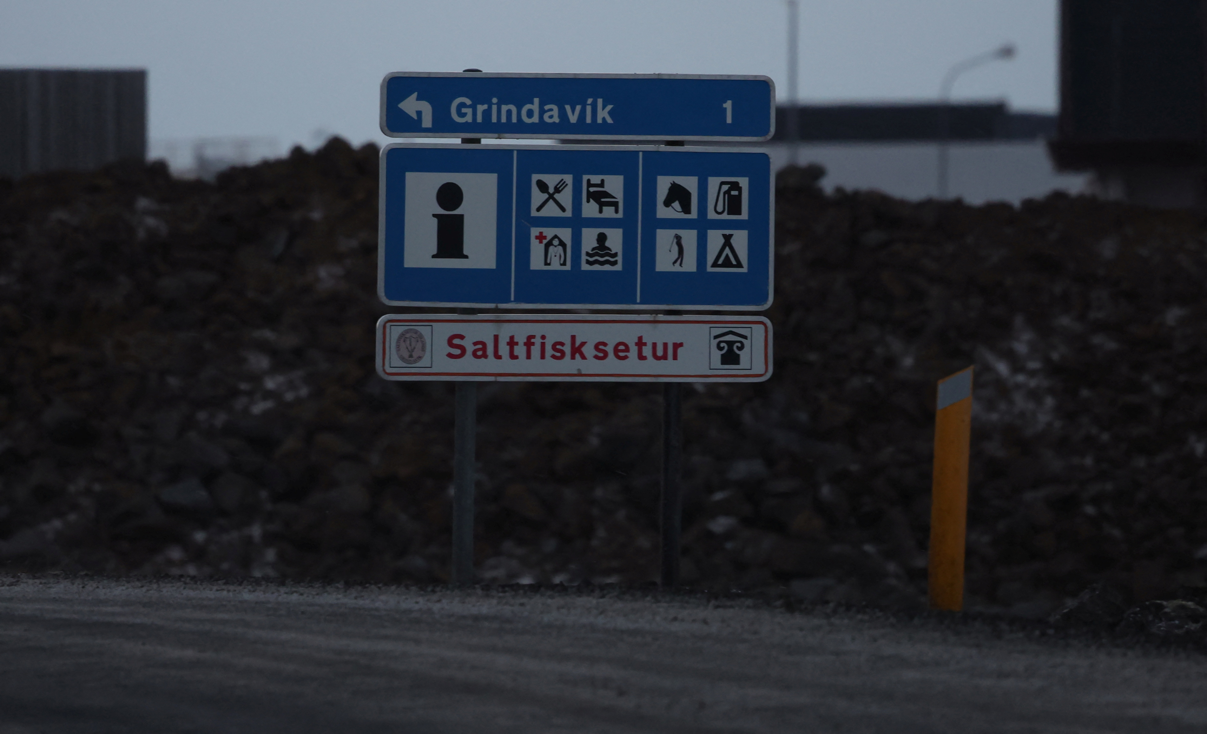 A sign is seen at the end of a road that has been closed following a volcanic eruption on the edge of the town of Grindavik