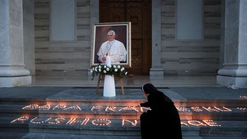 People offer candles after the death of Pope Francis in front of the Mother Teresa Cathedral, in Pristina