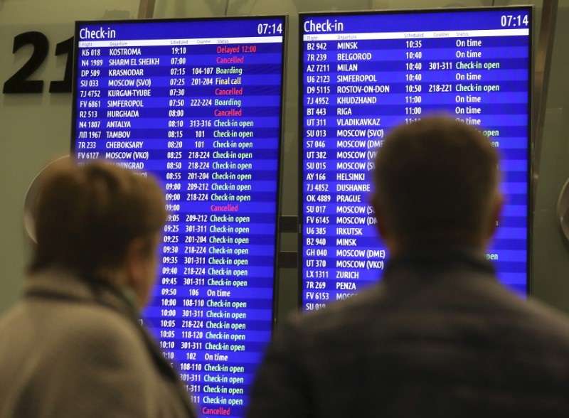 People look at an information board at Pulkovo airport outside St. Petersburg