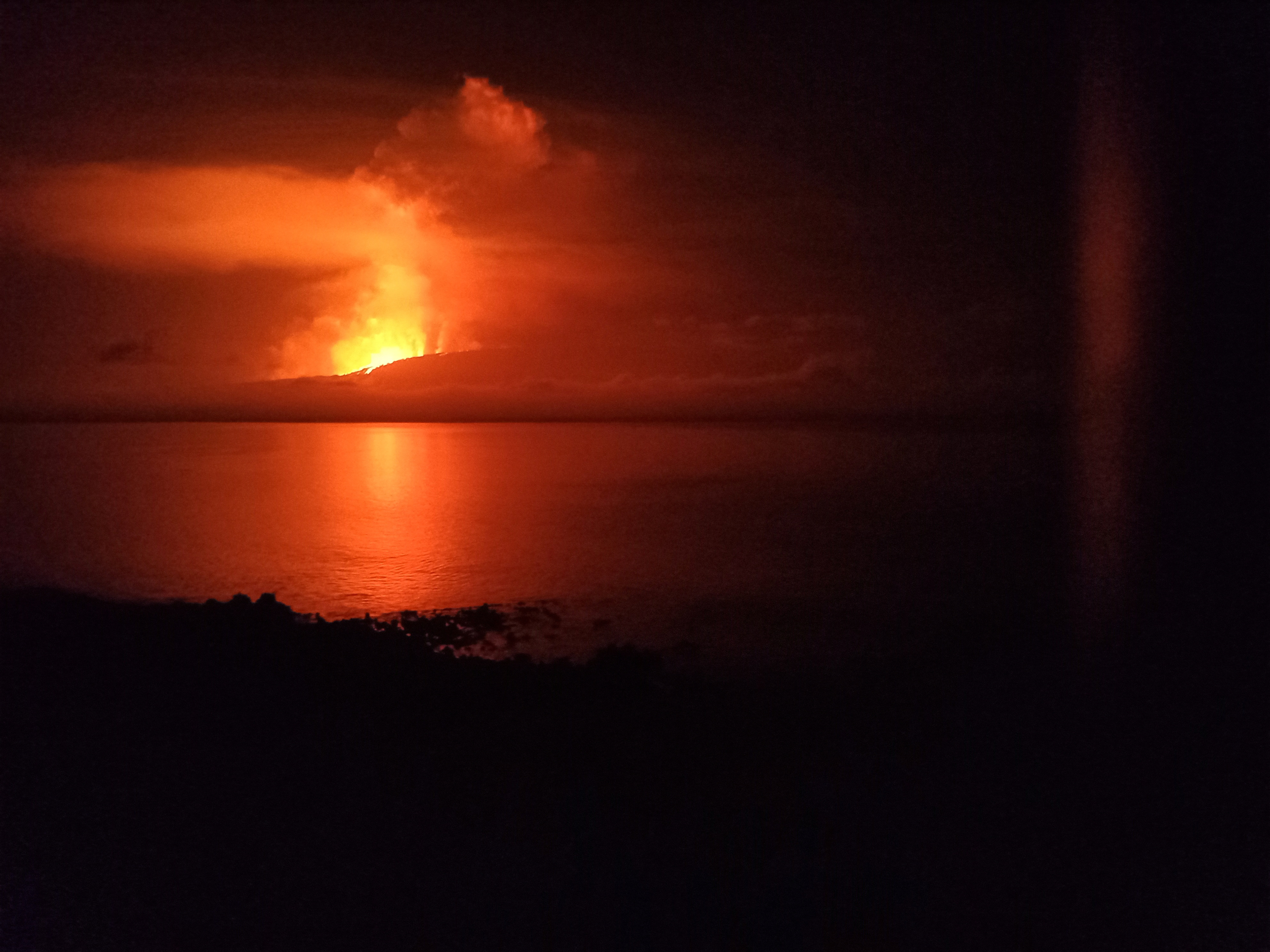 A view shows la cumbre volcano erupting and spewing lava, as seen from Isabela Island in Galapagos