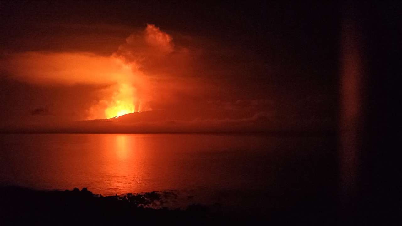 A view shows la cumbre volcano erupting and spewing lava, as seen from Isabela Island in Galapagos