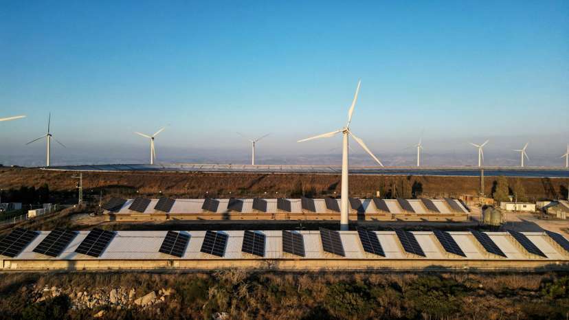 FILE PHOTO: Wind turbines and solar panels on the rooftops of an agricultural area at Kibbutz Maale Gilboa