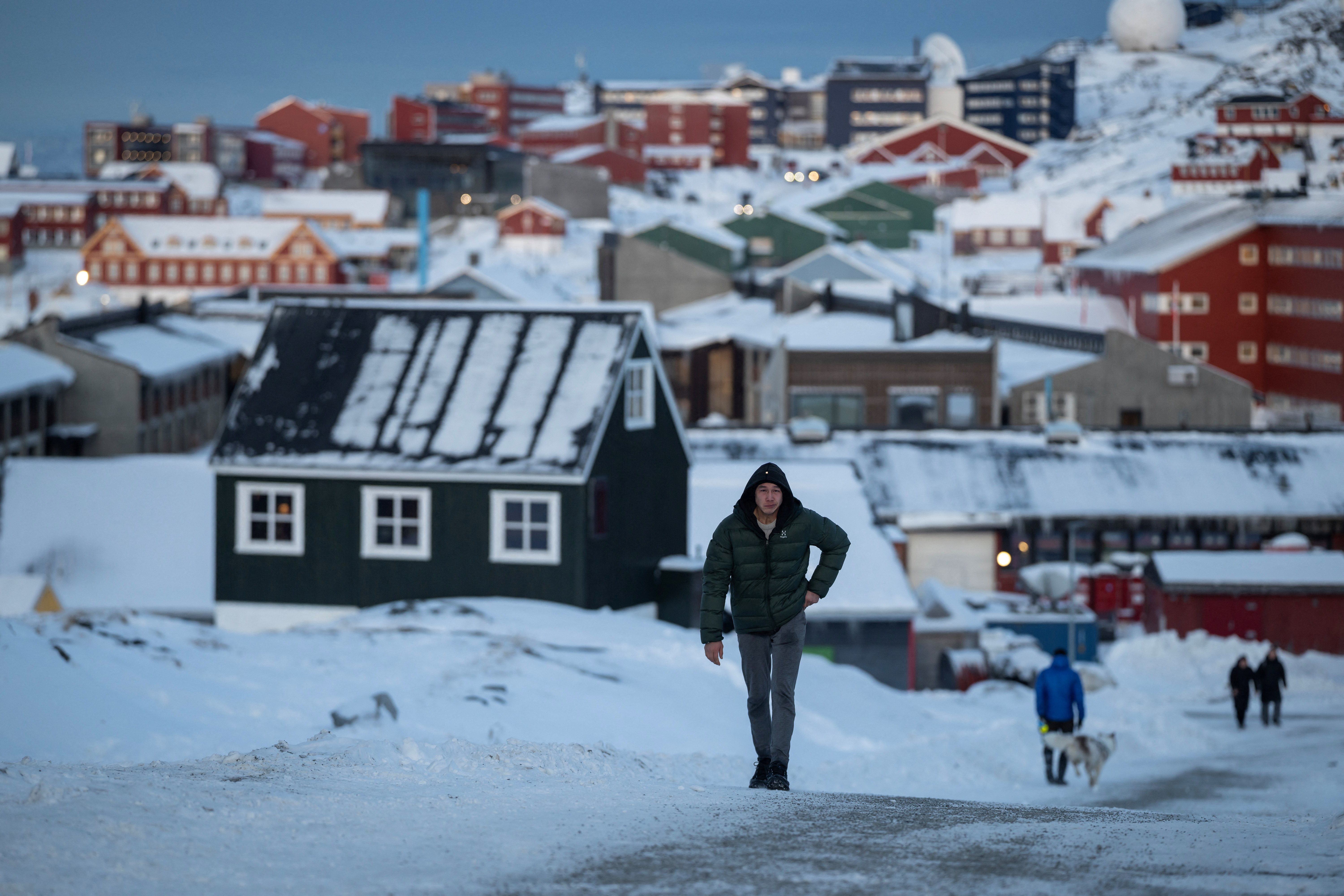 A man walks along a road on the day of the meeting between top U.S. officials and the foreign ministers of Denmark and Greenland, in Nuuk