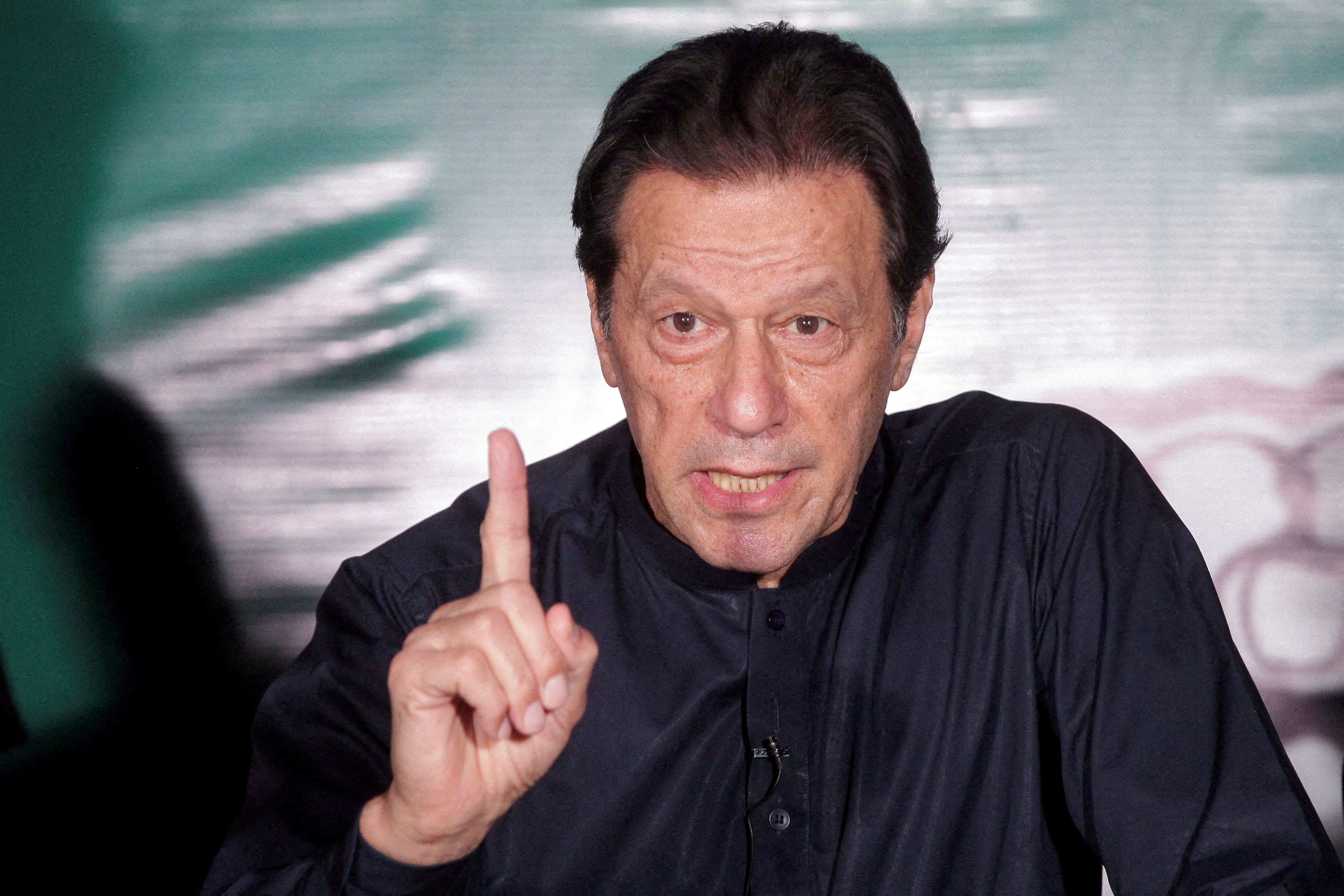 FILE PHOTO: Pakistan's former Prime Minister Imran Khan gestures as he speaks to the members of the media at his residence in Lahore