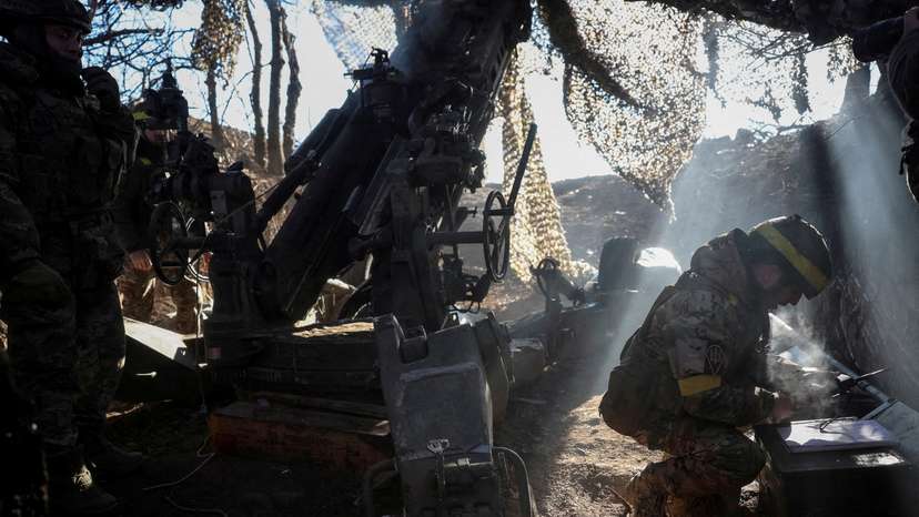 FILE PHOTO: Servicemen fire a howitzer towards Russian troops at a position in a front line in Donetsk region