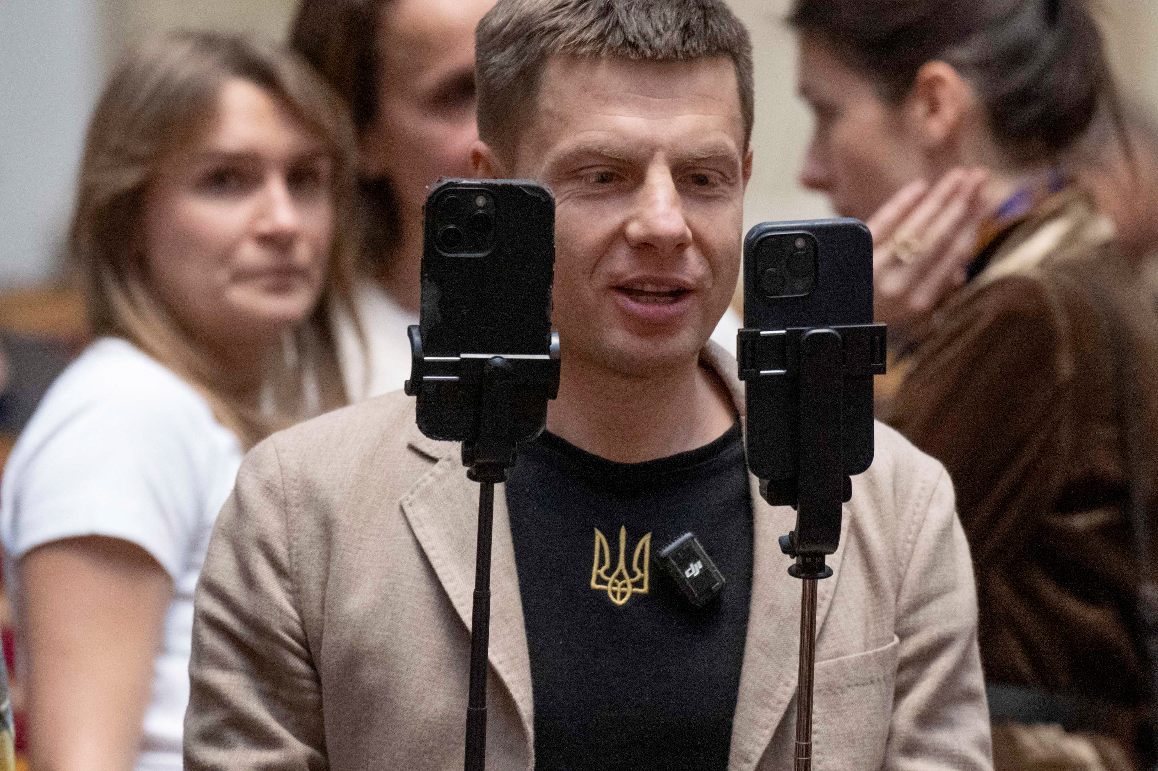 Lawmaker Oleksii Honcharenko holds smartphones as he live streams a session of Ukrainian parliament in Kyiv