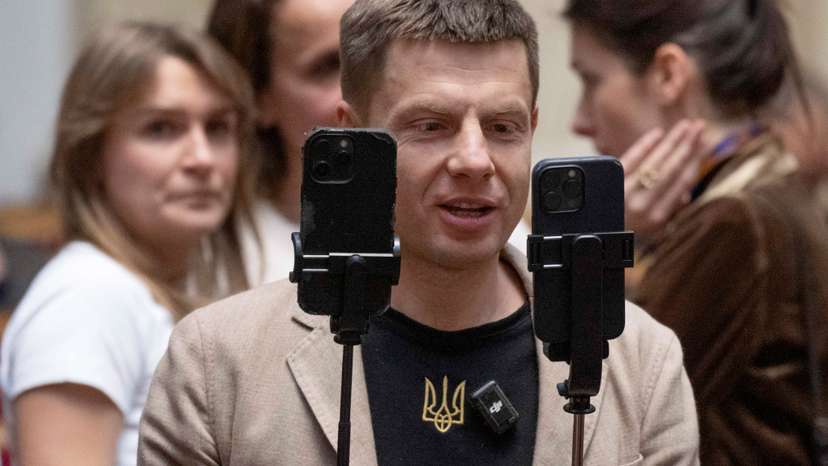 Lawmaker Oleksii Honcharenko holds smartphones as he live streams a session of Ukrainian parliament in Kyiv