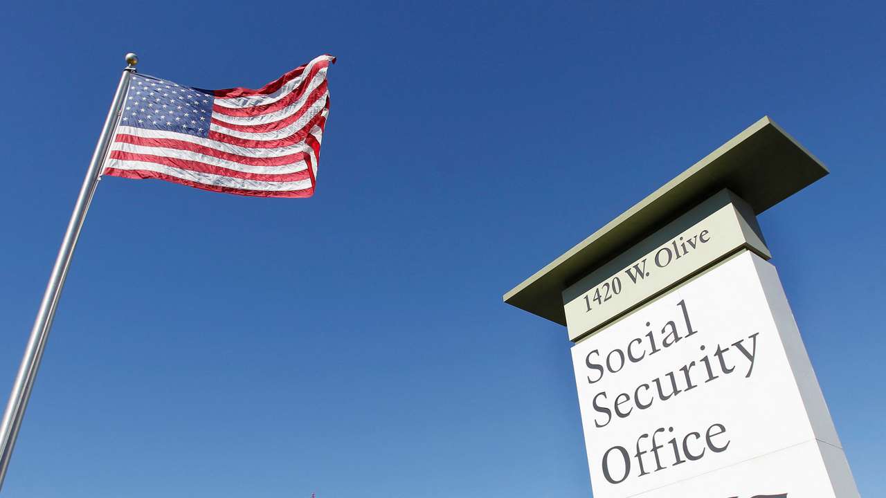FILE PHOTO: An American flag flutters in the wind next to signage for a U.S. Social Security Administration office in Burbank