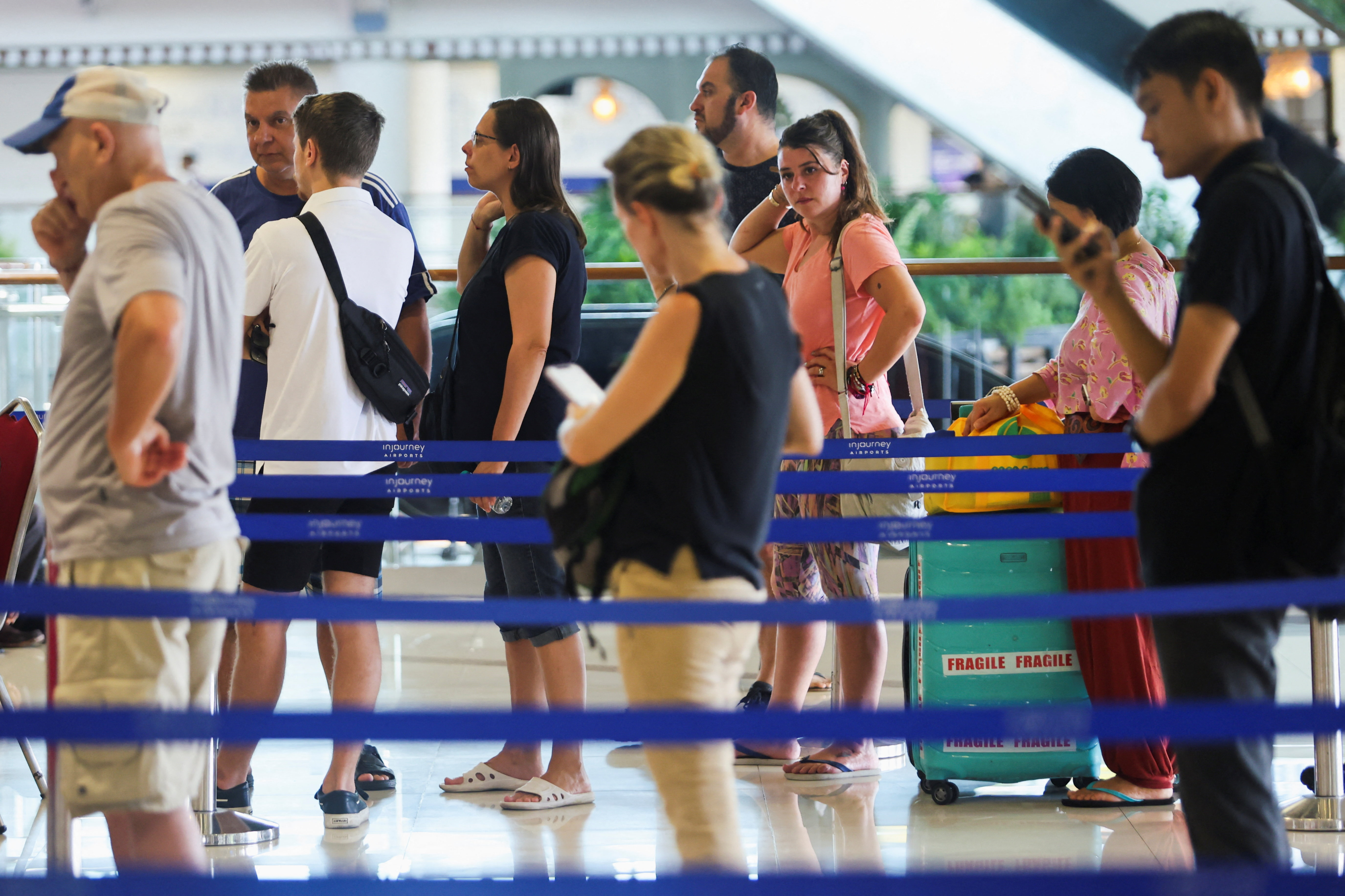 Stranded passengers at I Gusti Ngurah Rai International Airport after flights to Doha, Dubai, and Abu Dhabi were cancelled following strikes on Iran launched by the United States and Israel, in Kuta