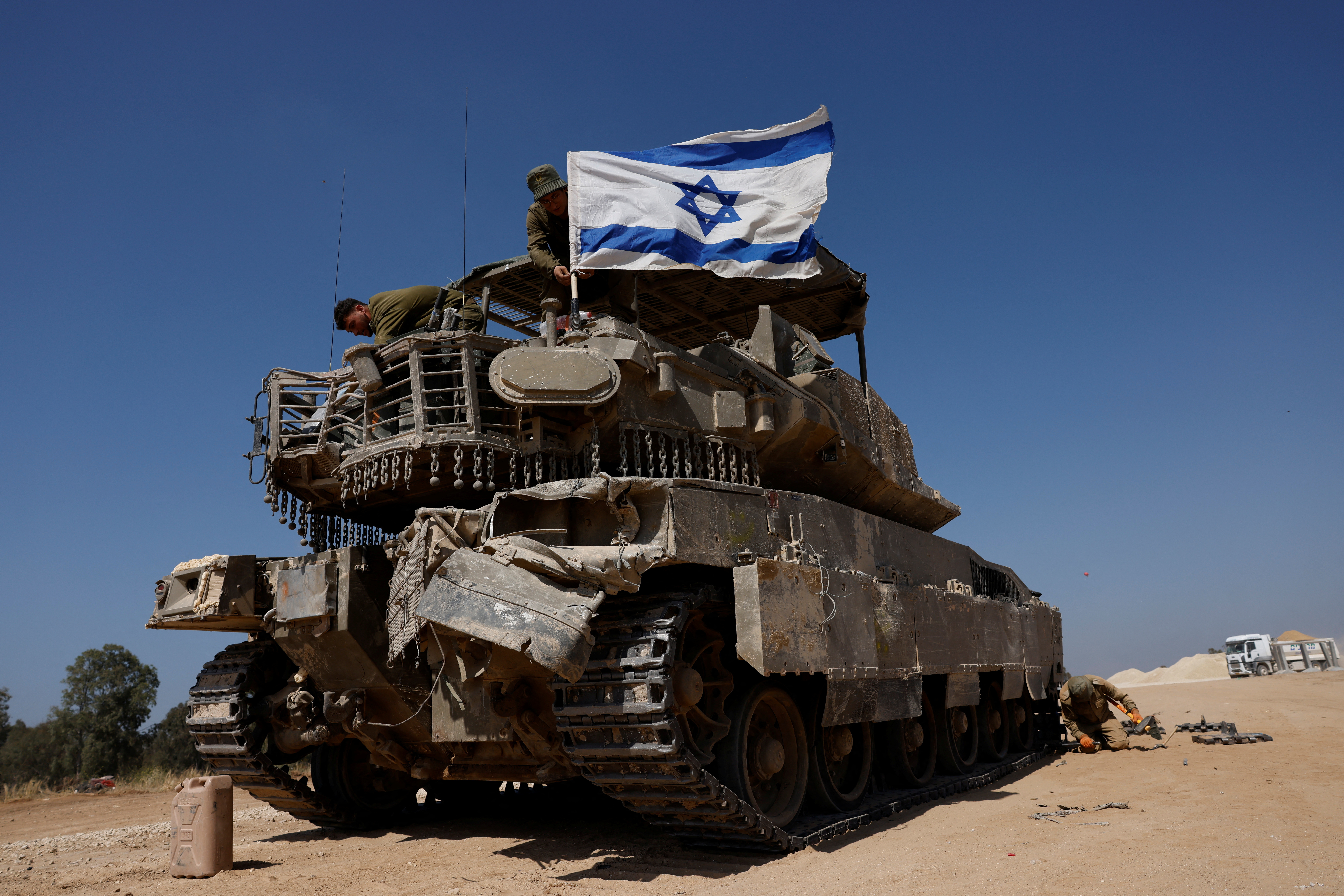 FILE PHOTO: Israeli soldiers mount a flag on a military vehicle near the Israel-Gaza border