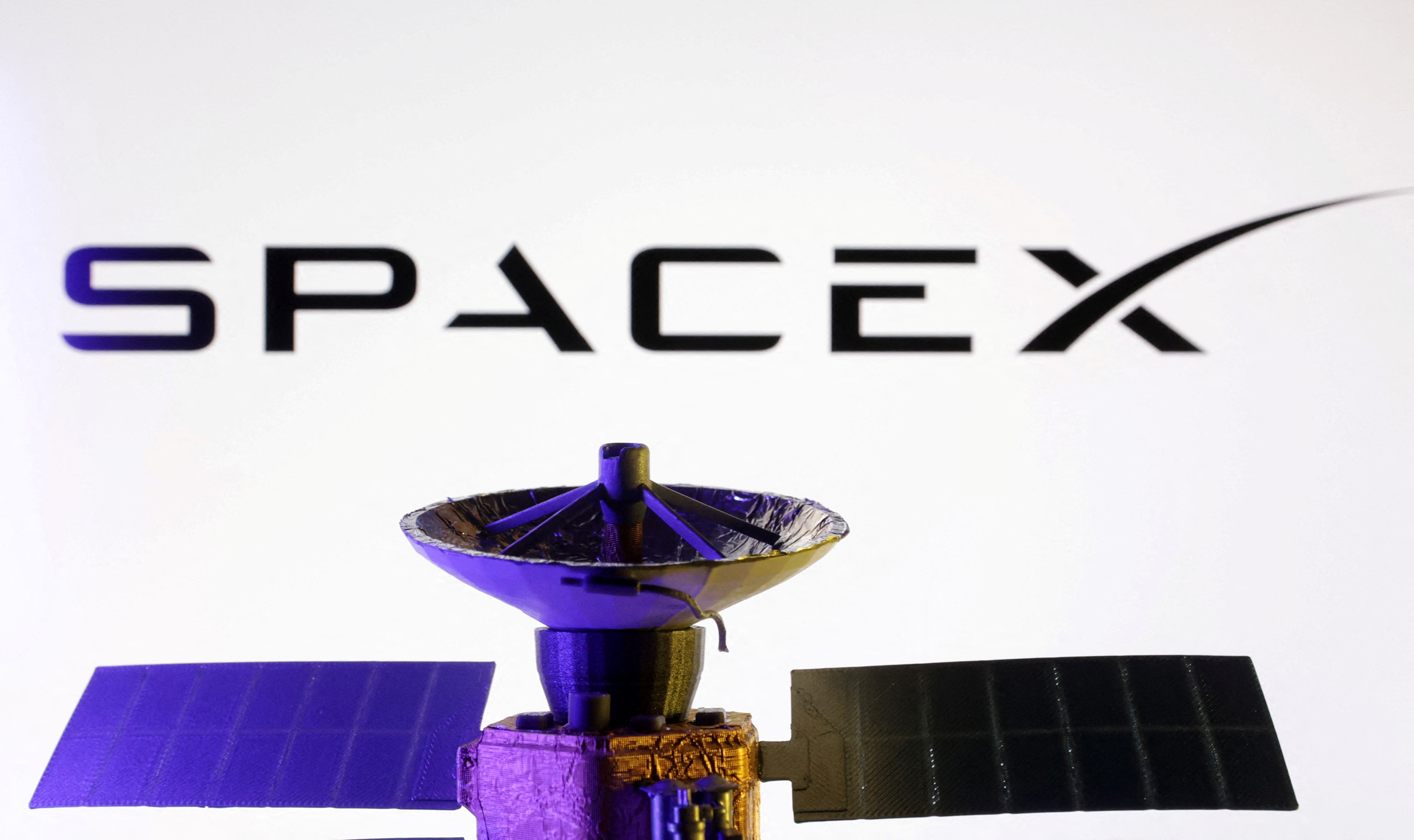 Illustration shows SpaceX logo and miniature satellite model