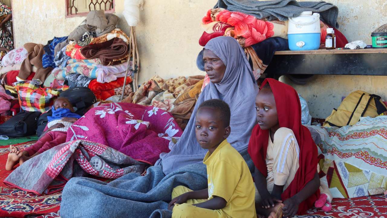 A Sudanese family, displaced from Gezira state due to RSF violence, sit at a shelter in New Halfa