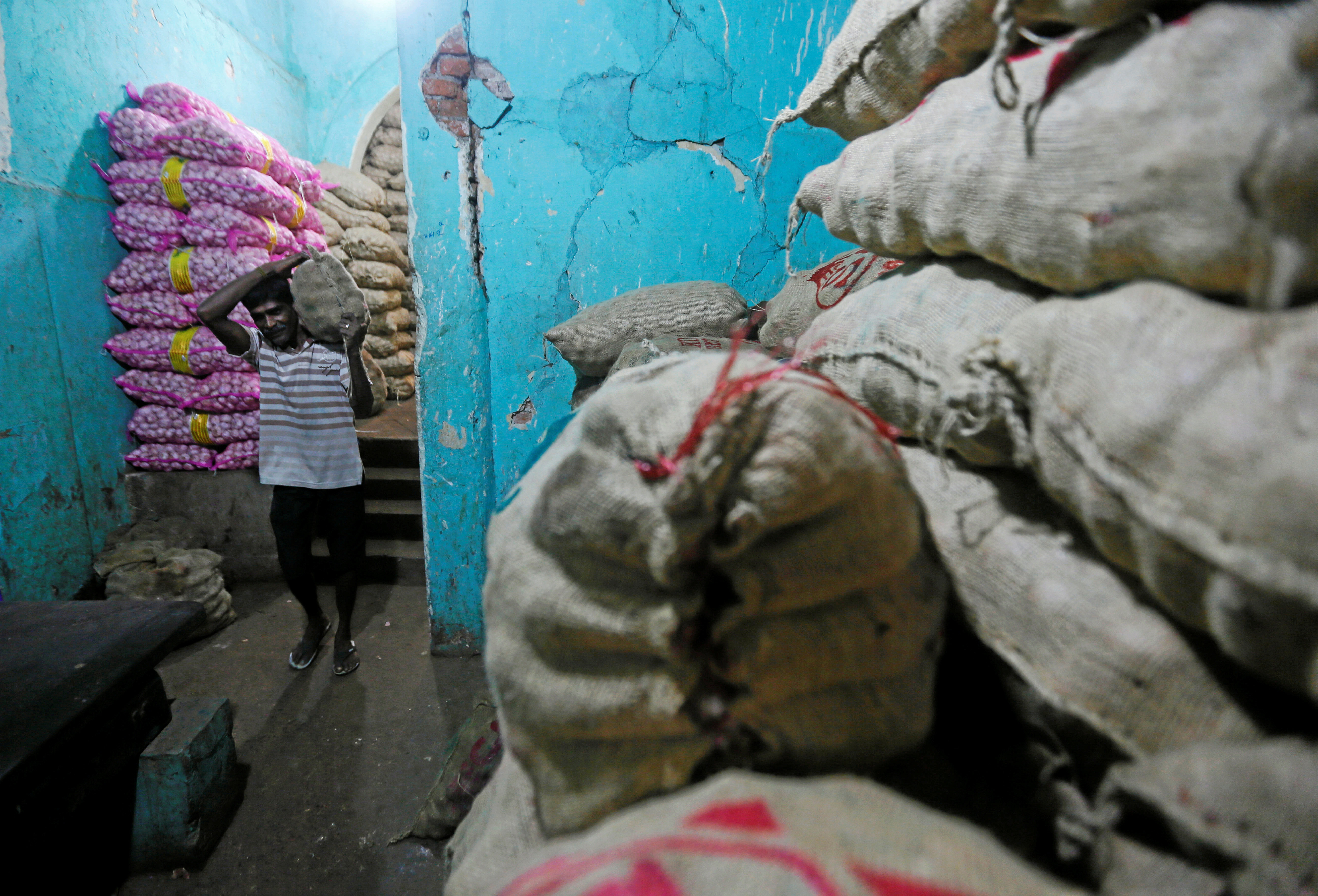 A worker carries a sack of imported potatoes near a main market in Colombo