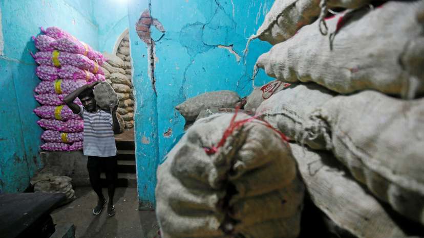 A worker carries a sack of imported potatoes near a main market in Colombo