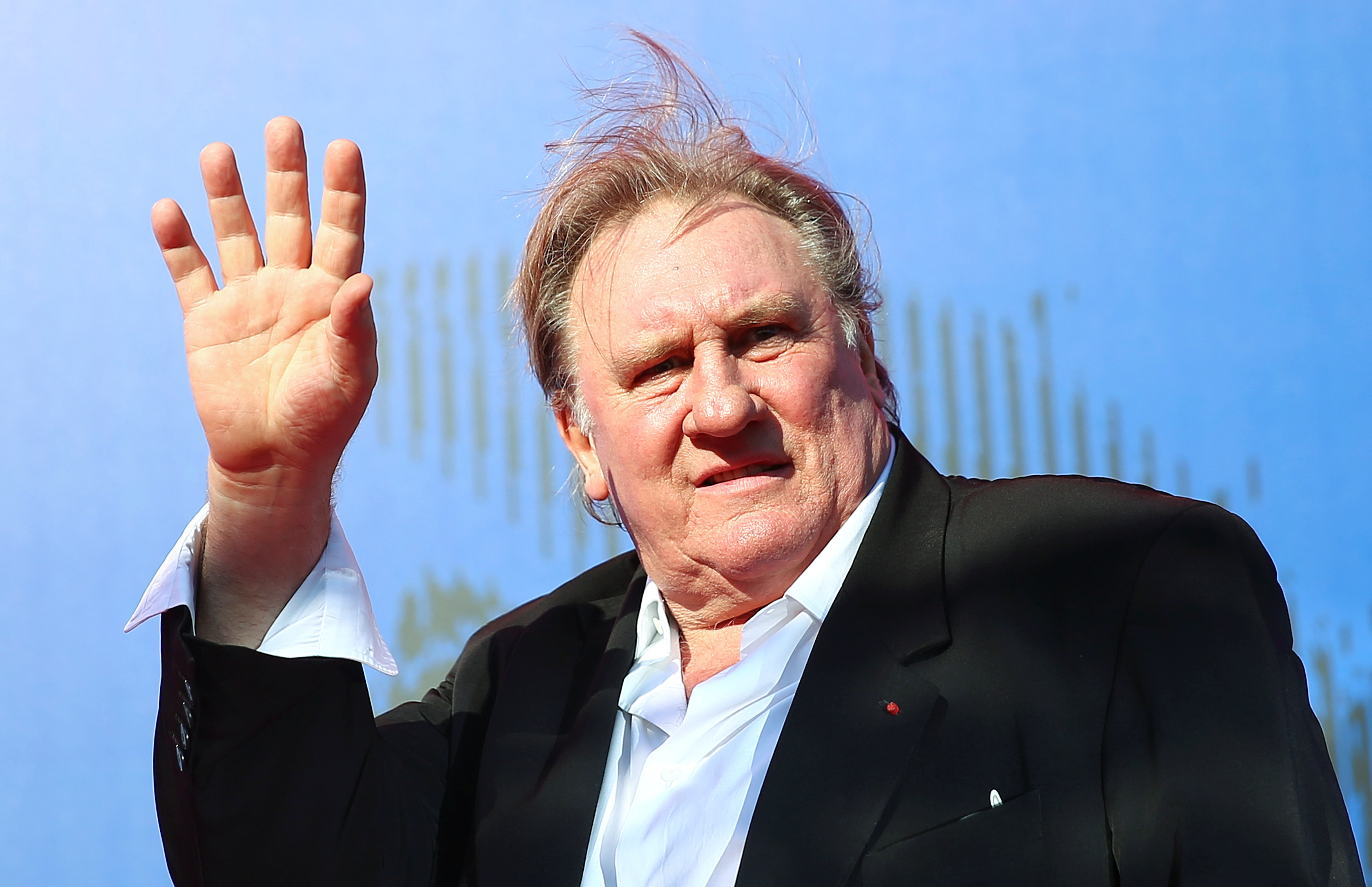 Gerard Depardieu waves as he arrives during a red carpet event for the movie "Novecento- Atto Primo" at the 74th Venice Film Festival in Venice