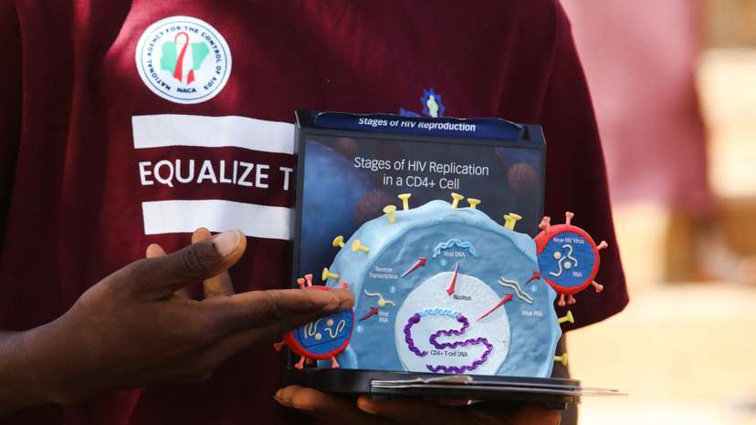 An educator uses a model of the HIV virus to illustrate a lesson on AIDS to youths at a primary health centre in Kobi suburb, Abuja