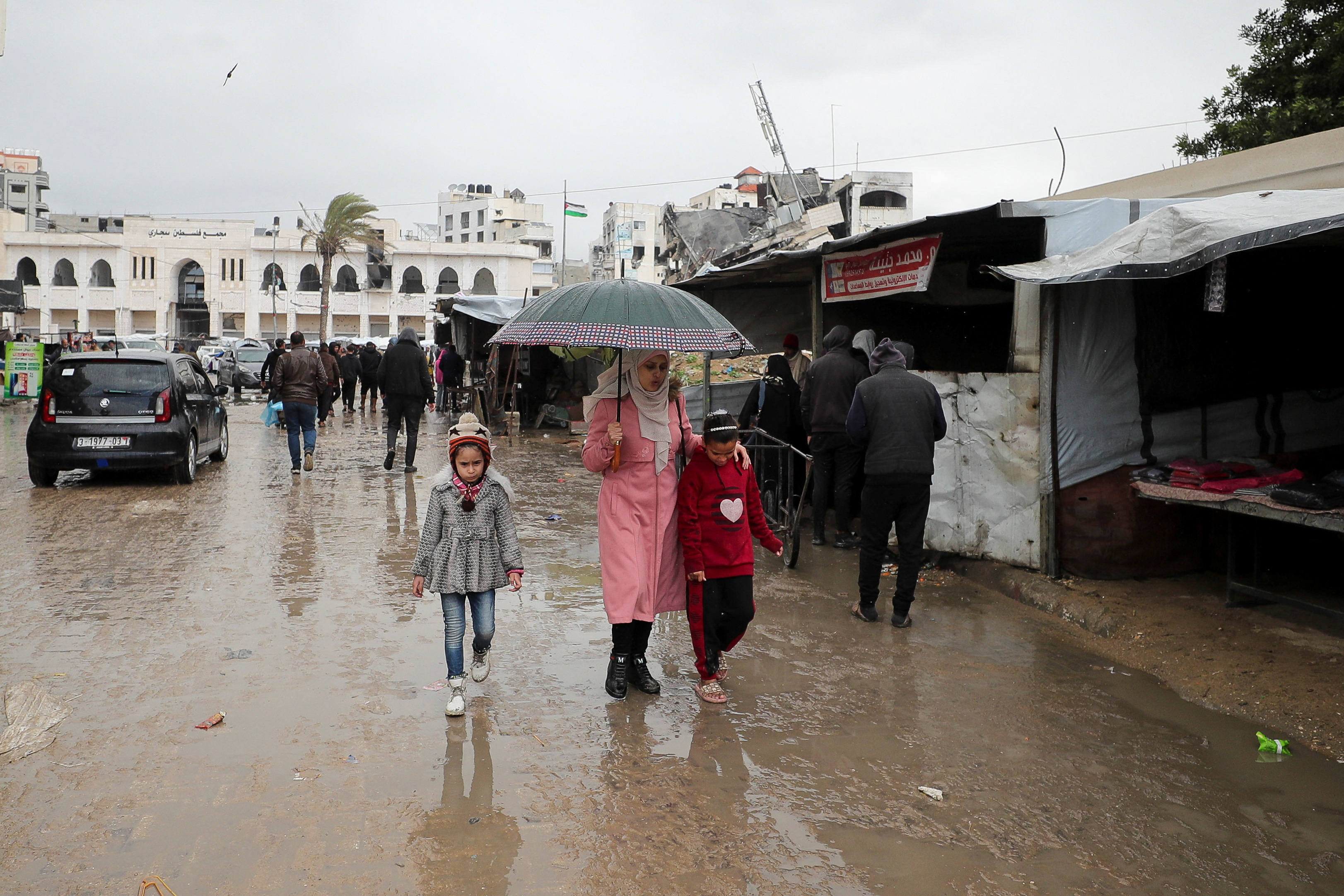 Palestinians walk on a road on a rainy day, amid a ceasefire between Israel and Hamas, in Gaza City