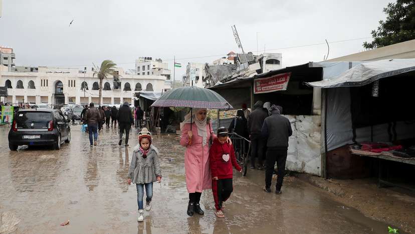 Palestinians walk on a road on a rainy day, amid a ceasefire between Israel and Hamas, in Gaza City