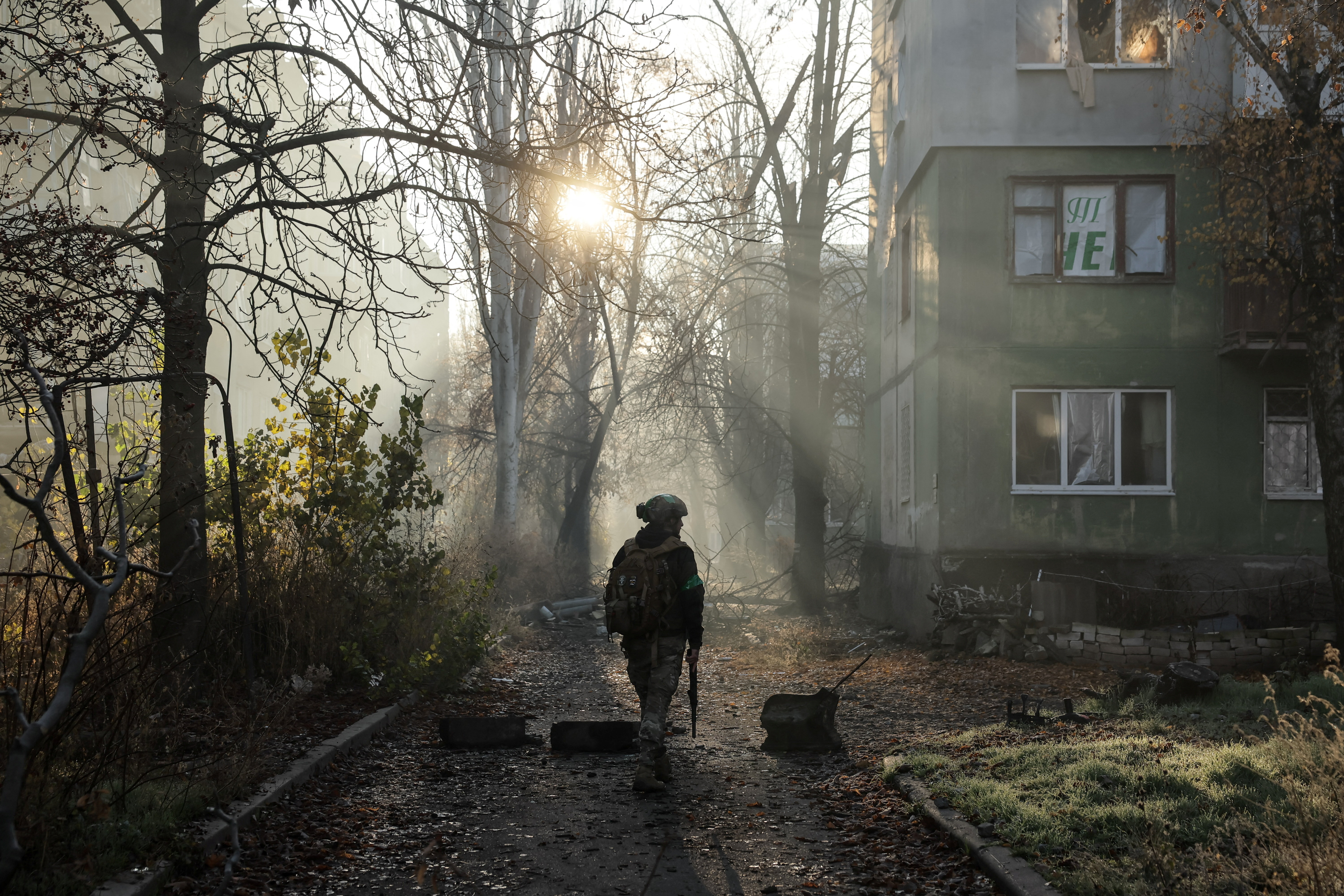 Ukrainian serviceman walks near apartment buildings damaged by Russian military strike in the frontline town of Kostiantynivka
