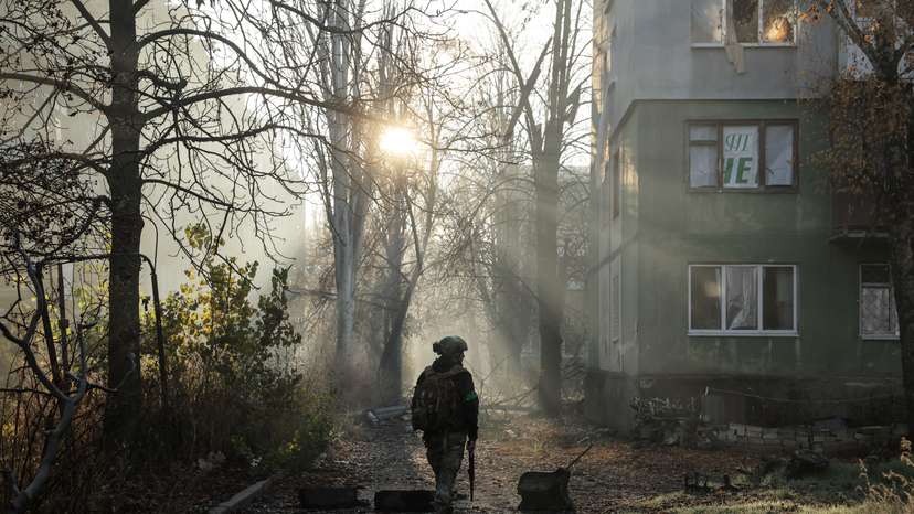 Ukrainian serviceman walks near apartment buildings damaged by Russian military strike in the frontline town of Kostiantynivka