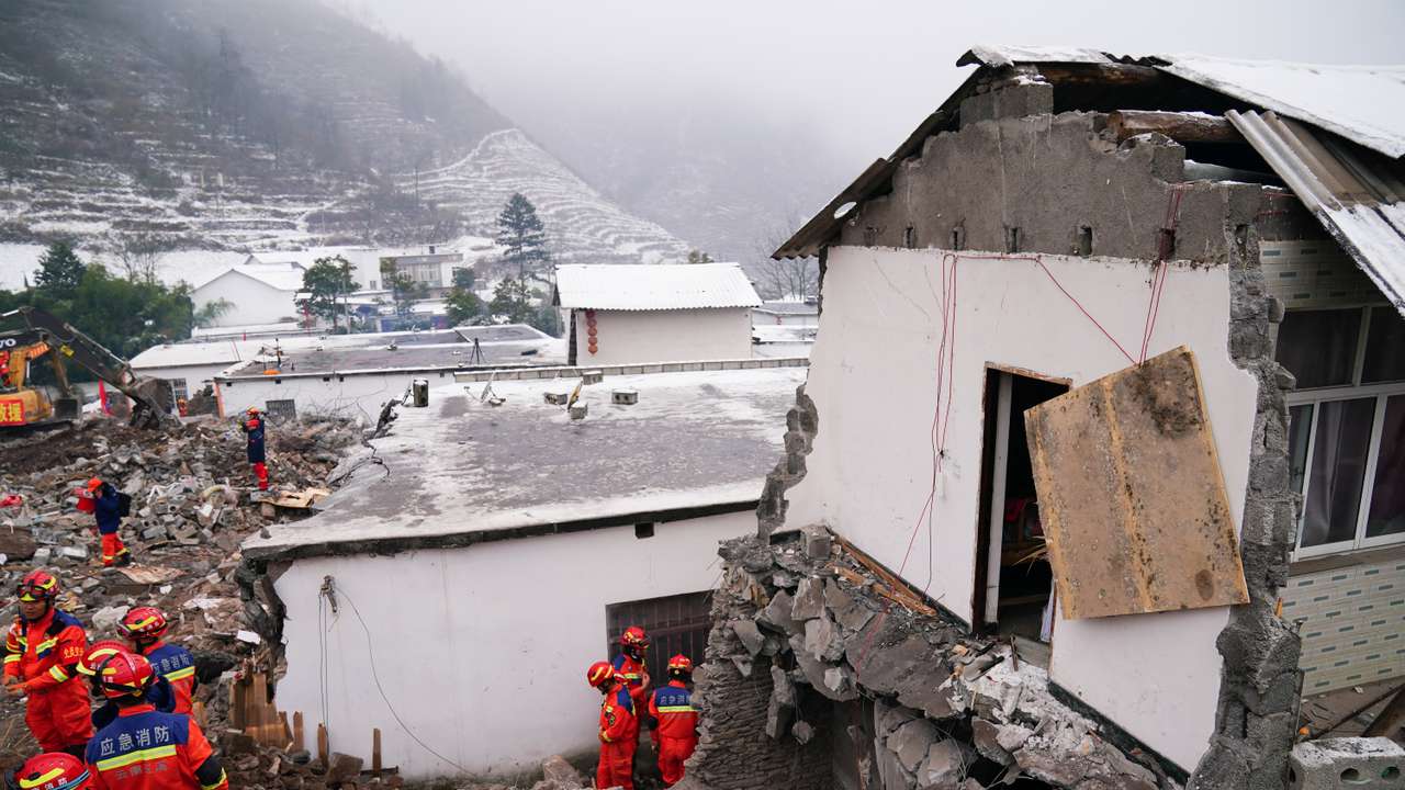 Rescue workers search for survivors near damaged houses after a landslide hit Zhenxiong county in Zhaotong