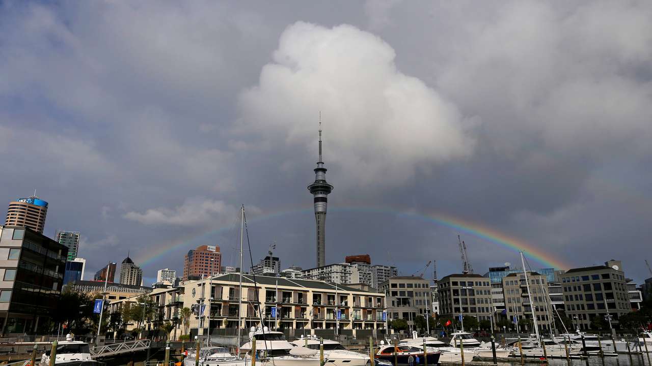 A rainbow appears on the Auckland skyline featuring Sky Tower in New Zealand