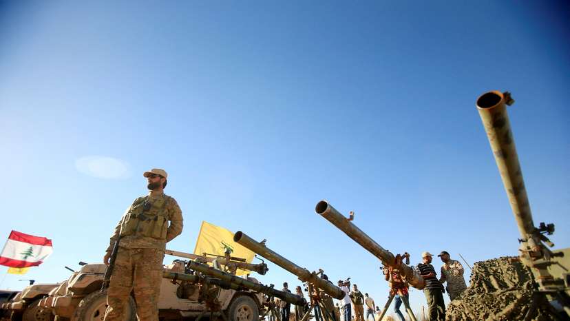 FILE PHOTO: A Hezbollah fighter stands in front of anti-tank artillery at Juroud Arsal