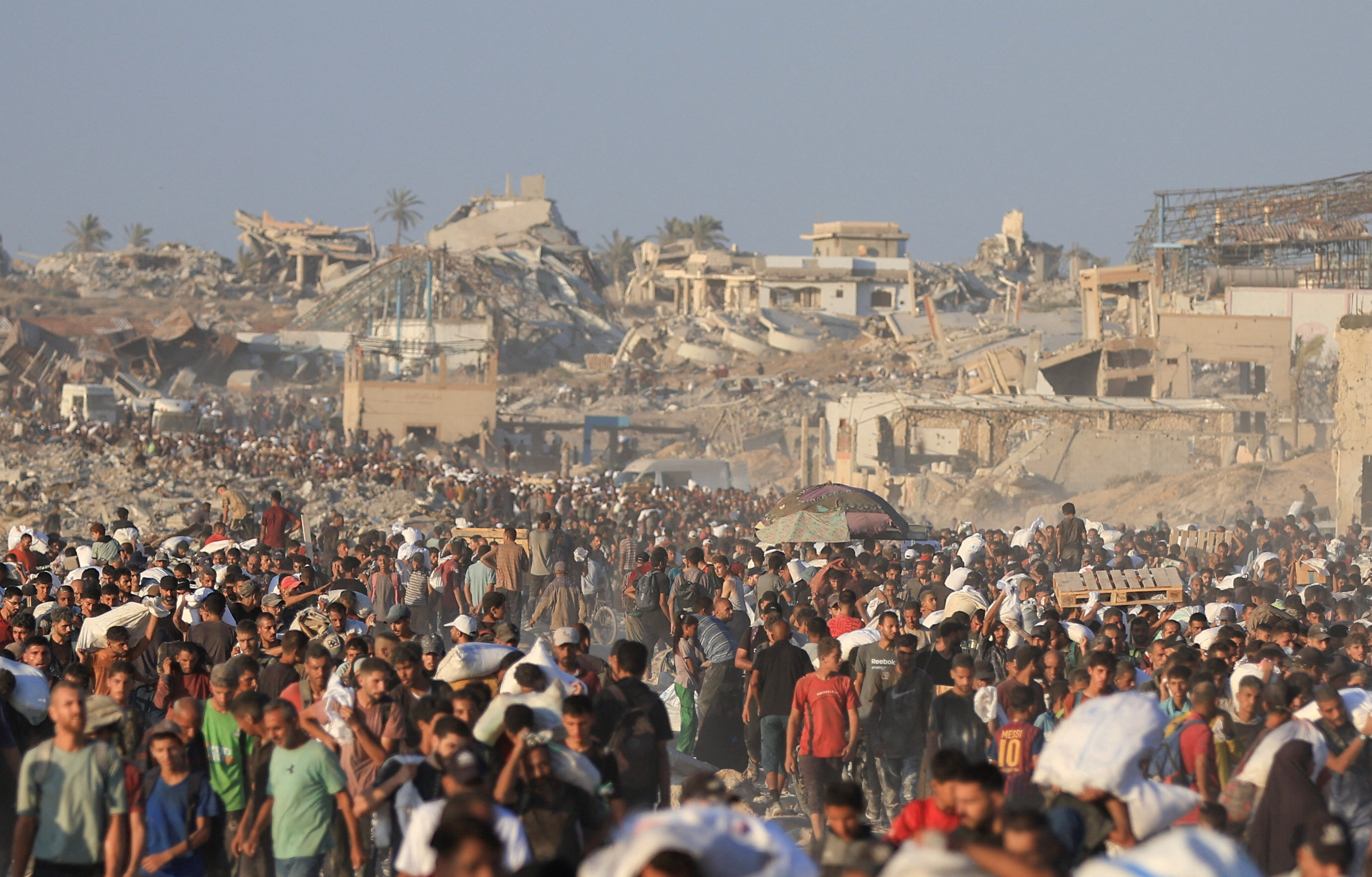 Palestinians carry aid supplies that entered Gaza through Israel, in Beit Lahia