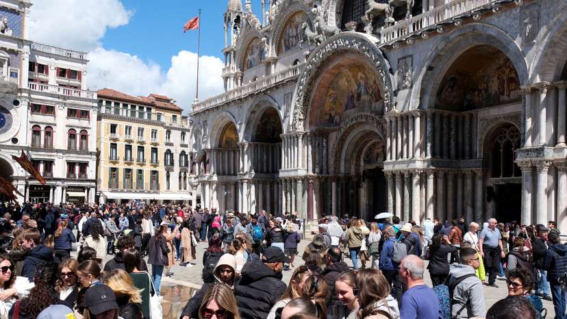 FILE PHOTO: Tourists walk in St Mark's Square on the day Venice municipality introduces a new fee for day