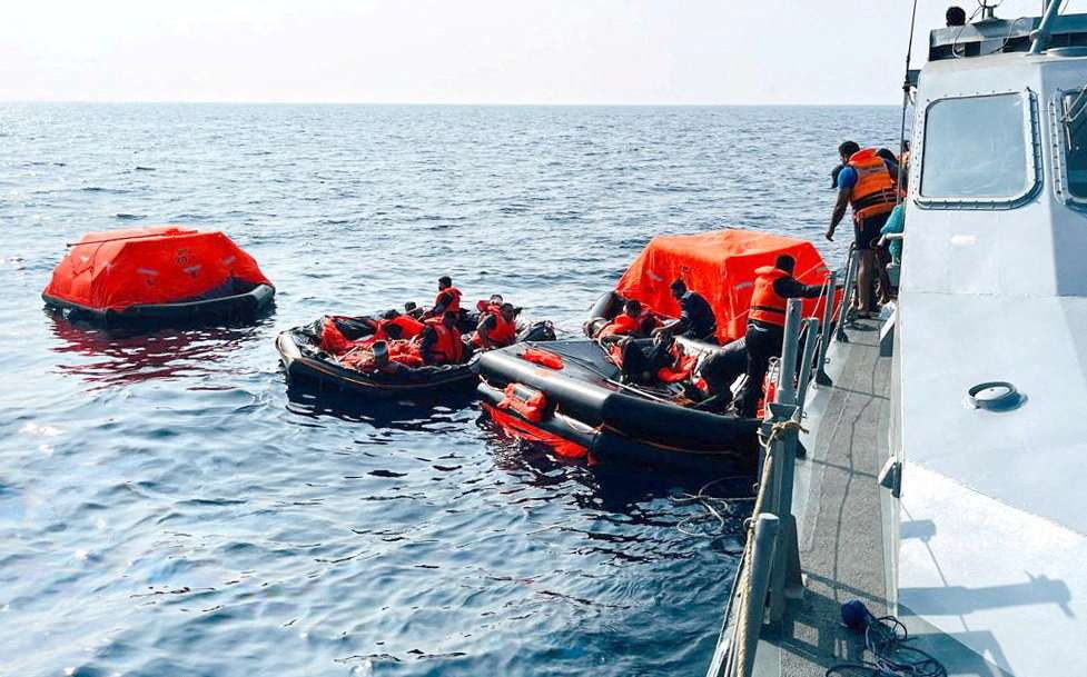 Sri Lanka Navy personnel assist Iranian sailors during a rescue operation in Indian Ocean