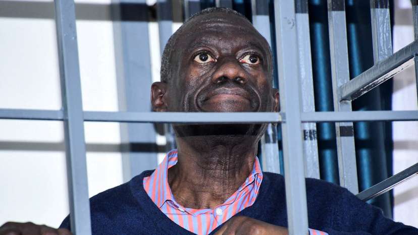 FILE PHOTO: Opposition leader Kizza Besigye stands in a steel dock at the Uganda Military General Court Martial in Makindye, a suburb of Kampala