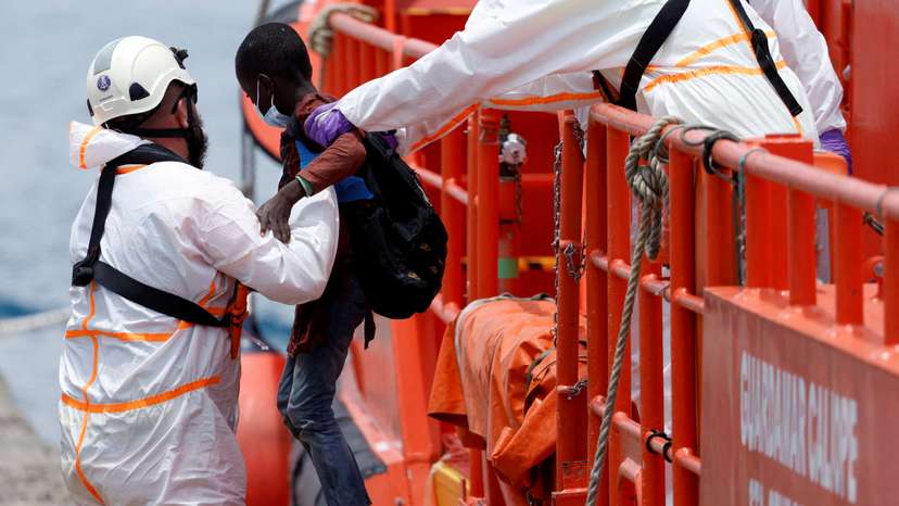 FILE PHOTO: A rescuer helps a migrant child disembark from a Spanish coast guard vessel in the port of Arguineguin
