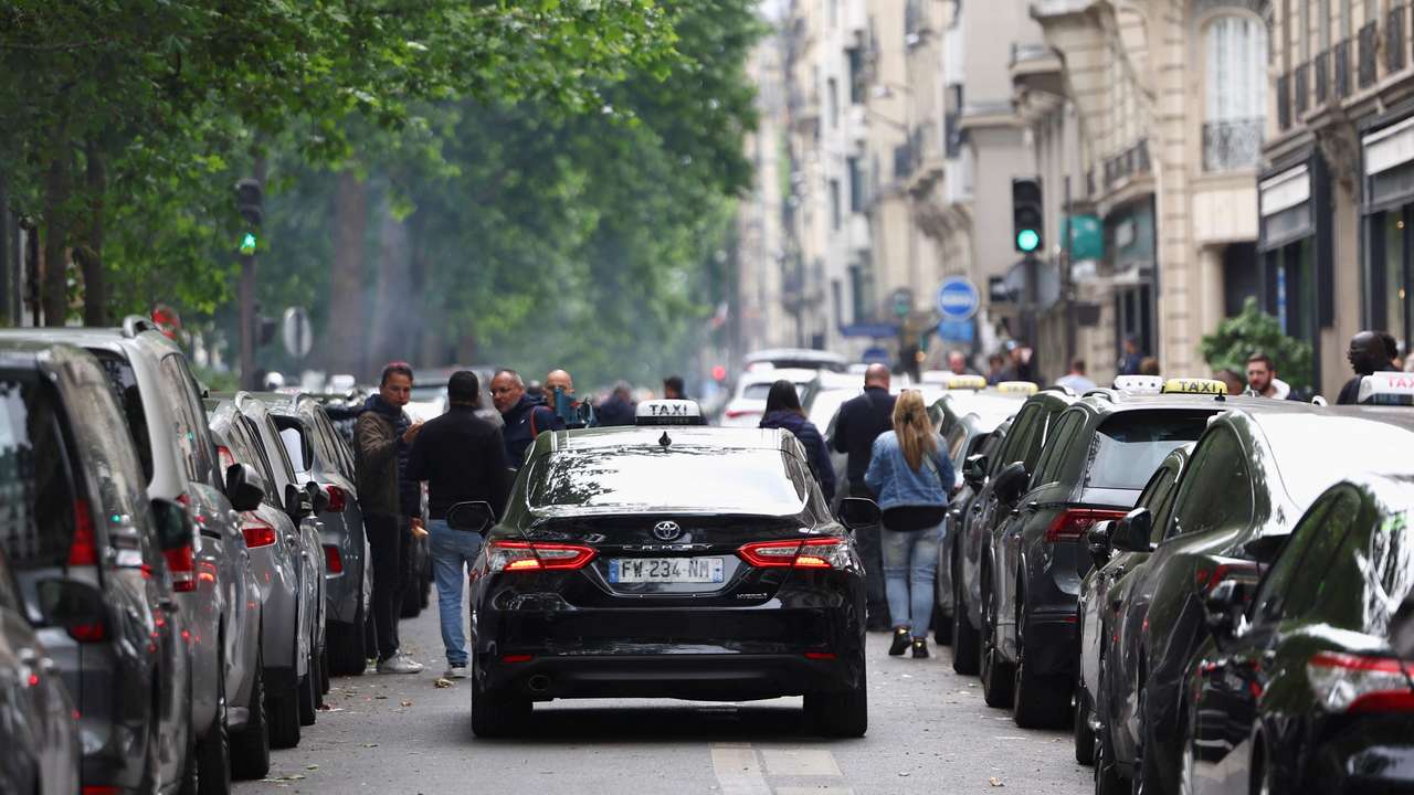French taxi drivers gather for a strike protesting over proposed government cuts to cash for ferrying patients to and from medical appointments, in Paris