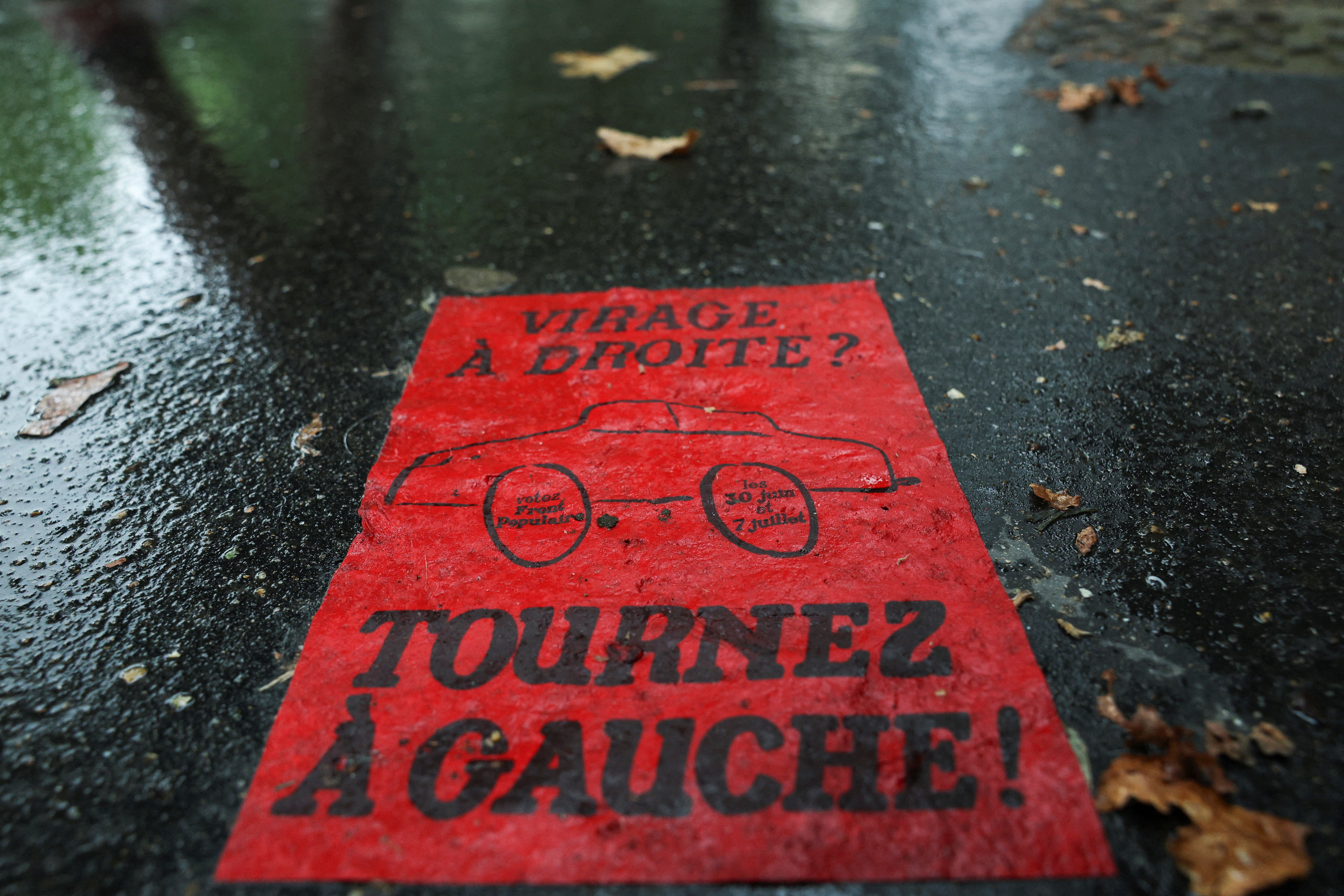 A flyer reading "Right turn? Turn left!" lies on the pavement prior to the second round of the early French parliamentary elections