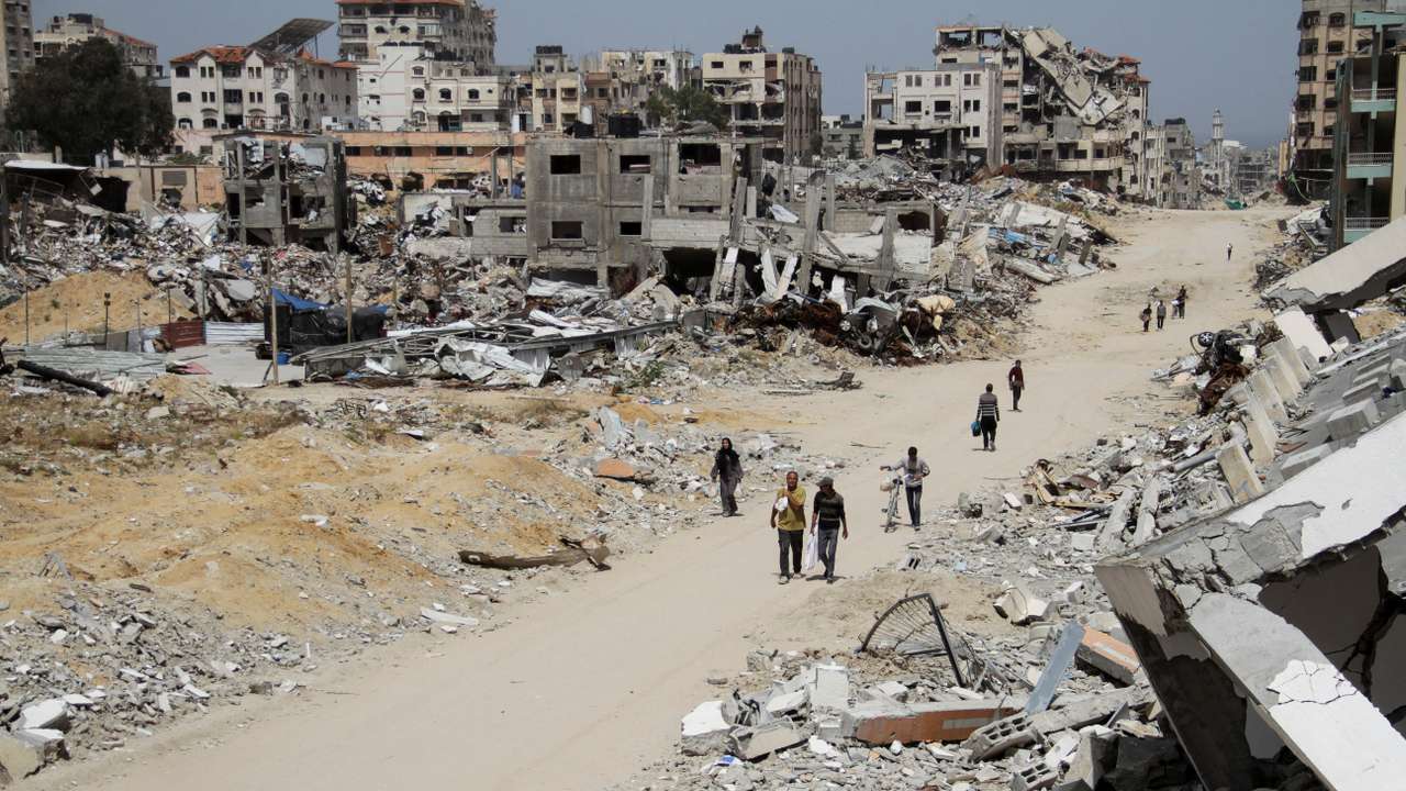 Palestinian woman Asmaa Al-Belbasi making her way back to her shelter after buying bread from a bakery, in Gaza City