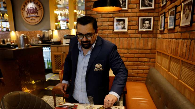 Amit Bagga, CEO of Daryaganj restaurant, shows a freshly prepared butter chicken dish and the lentil dish Dal Makhani, inside Daryaganj restaurant at a mall, in Noida