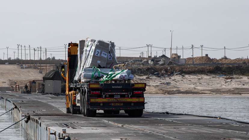 FILE PHOTO: Trucks deliver humanitarian aid over a temporary pier on the Gaza coast