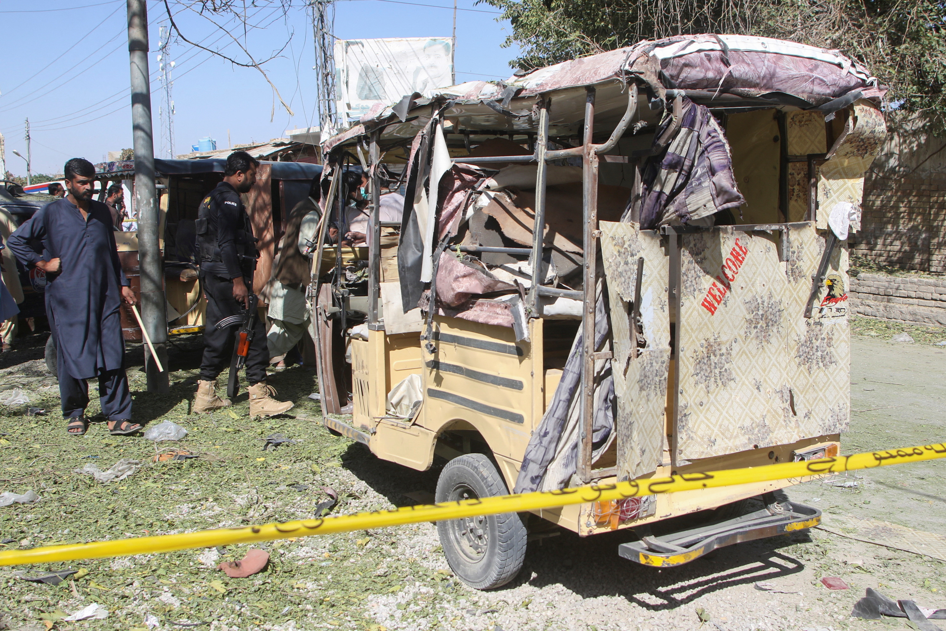 A member of the bomb disposal squad and a police officer survey the crime scene after a blast in Mastung