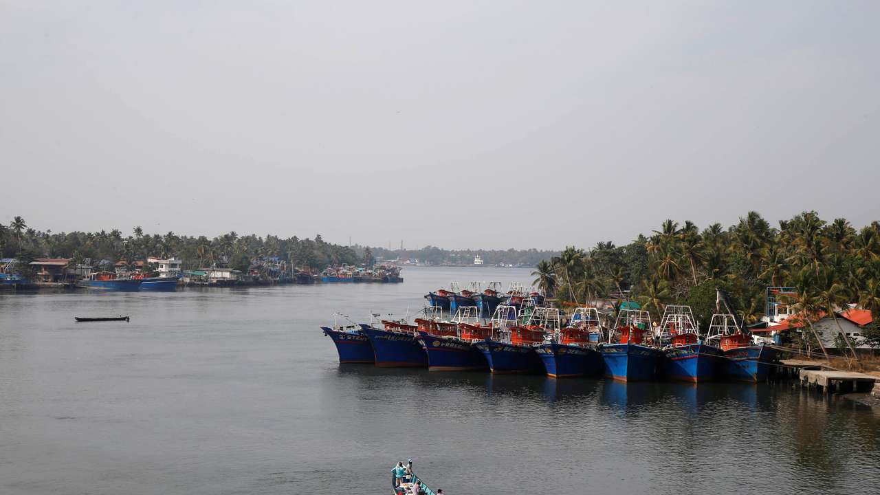 Fishermen travel in a boat in the tributary waters of the Periyar River at Munambam on the outskirts of Kochi