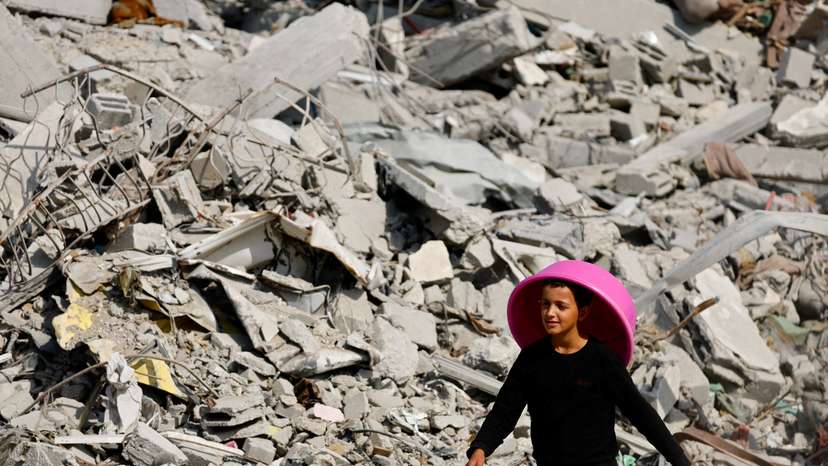 FILE PHOTO: A Palestinian youth walks past the rubble of destroyed buildings, amid a ceasefire between Israel and Hamas, in Gaza City