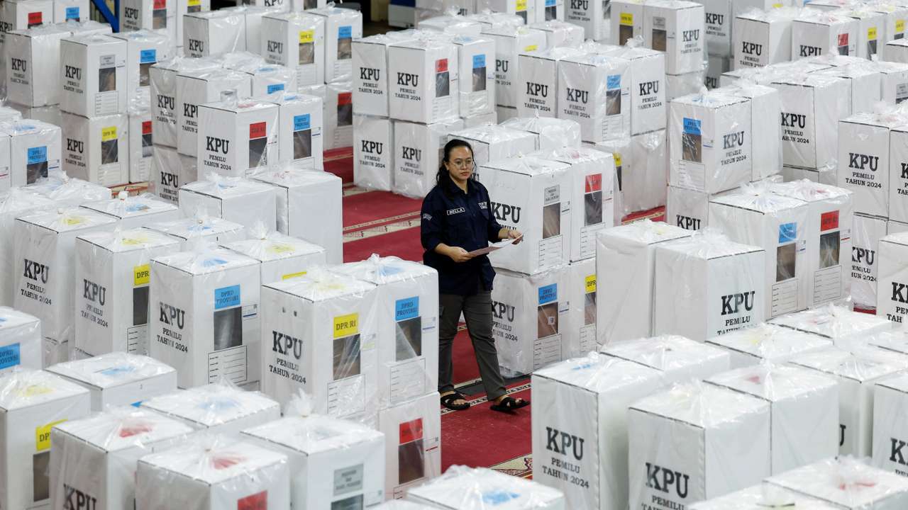 An election commission officer walks among ballot boxes ahead of the general election in Jakarta